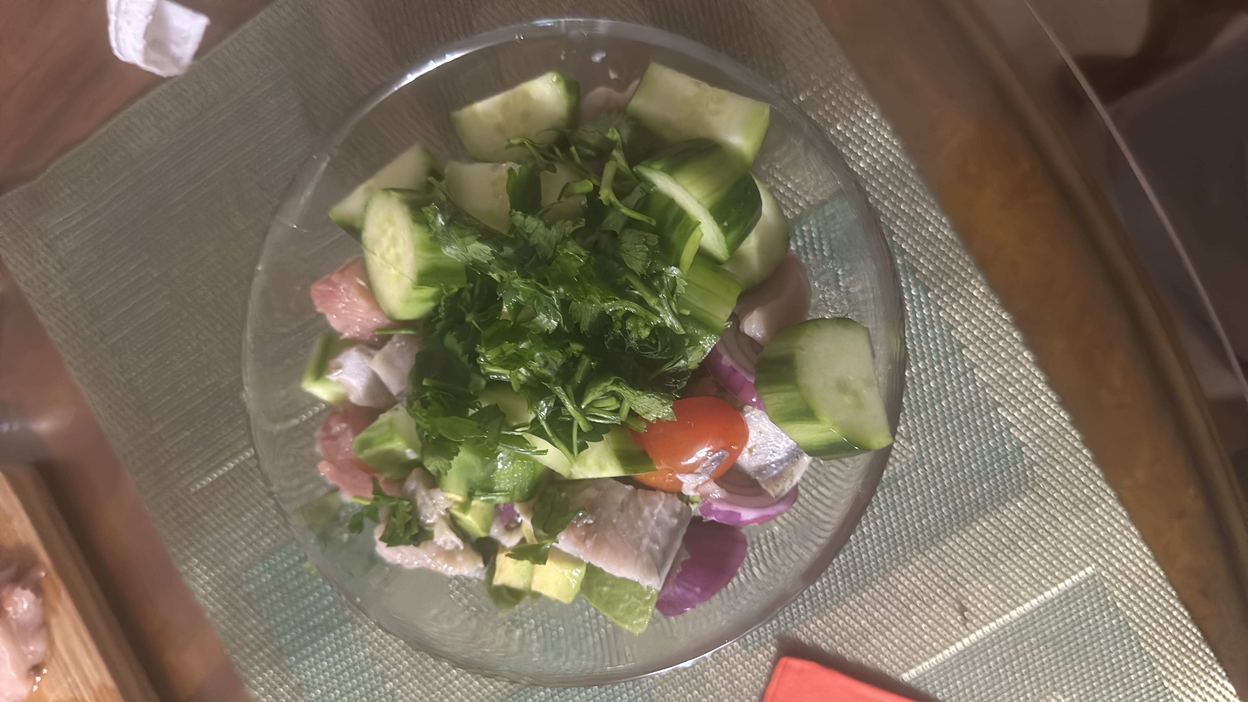 A fresh and healthy 500g salad containing cucumber, tomato, onion, cilantro, and fish, providing a balanced mix of protein, carbs, and fats.