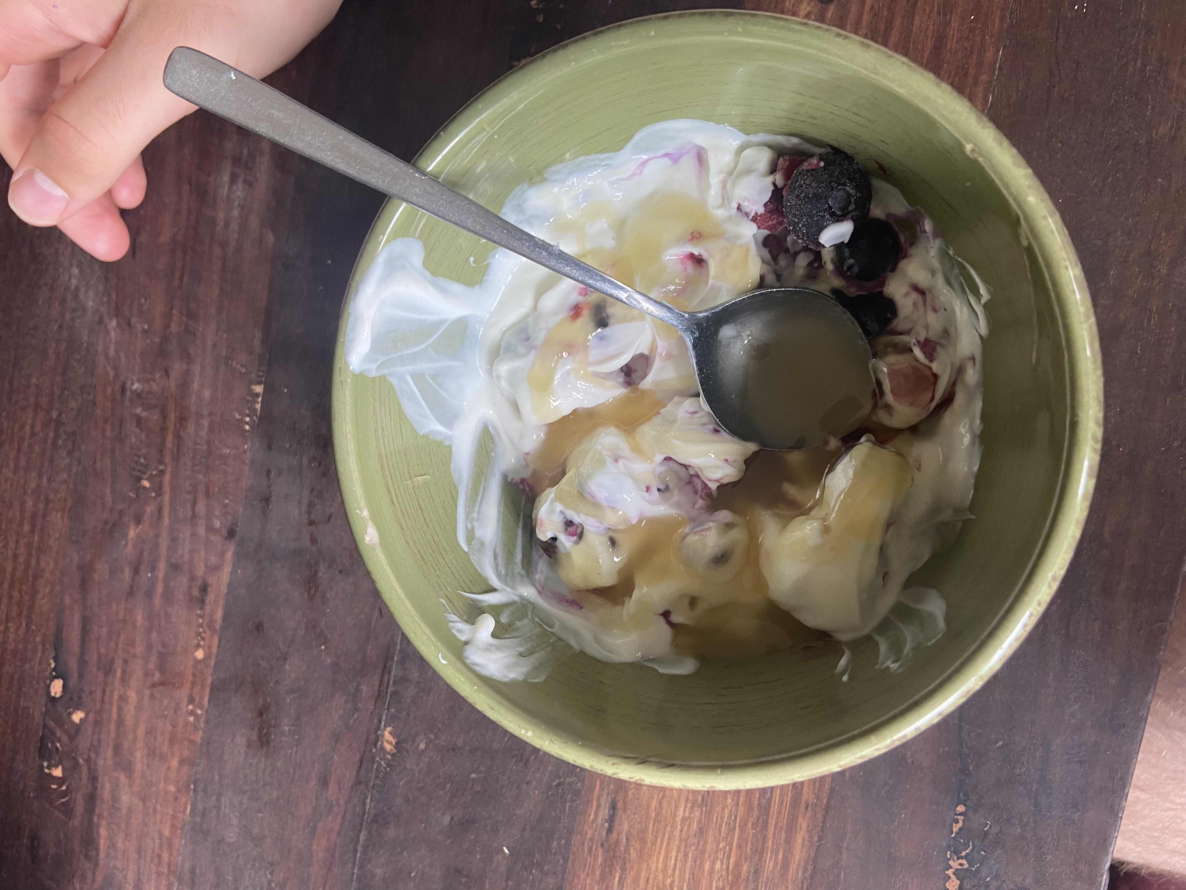 A bowl of yogurt topped with honey and mixed berries, providing a balanced mix of protein, carbs, and fats.