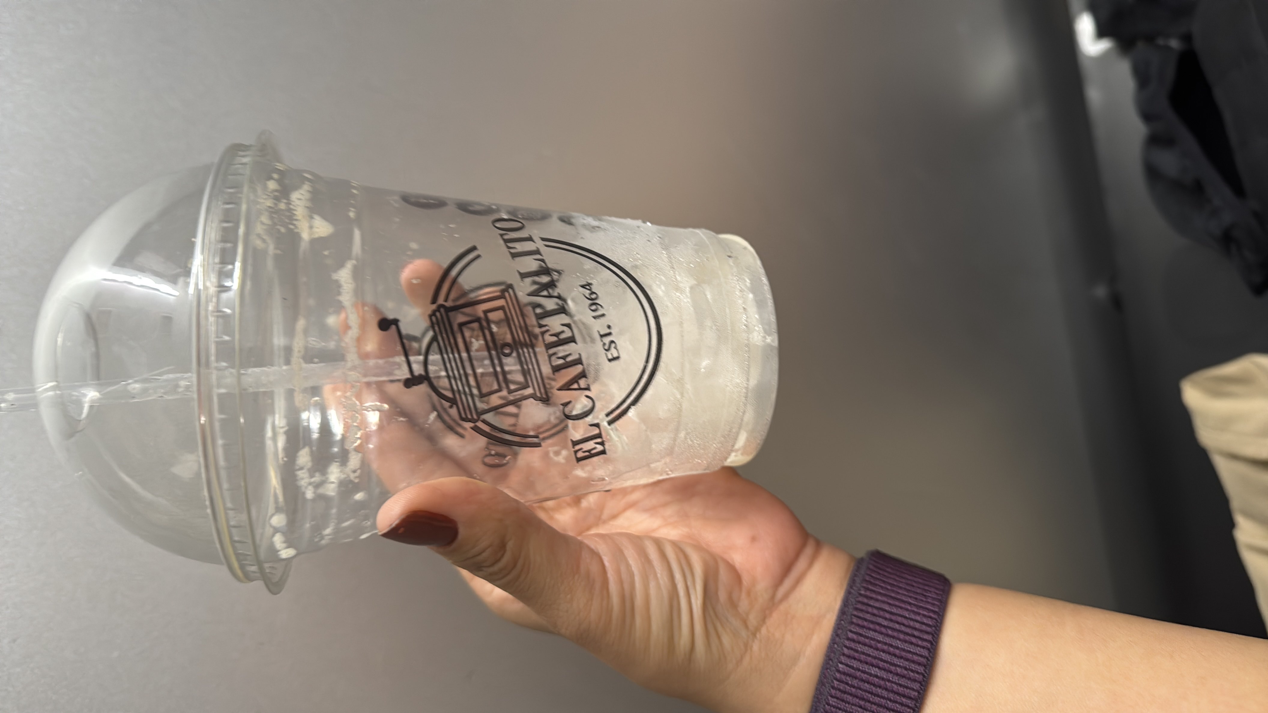 The image shows an empty plastic cup with remnants of ice, suggesting no significant nutritional content.