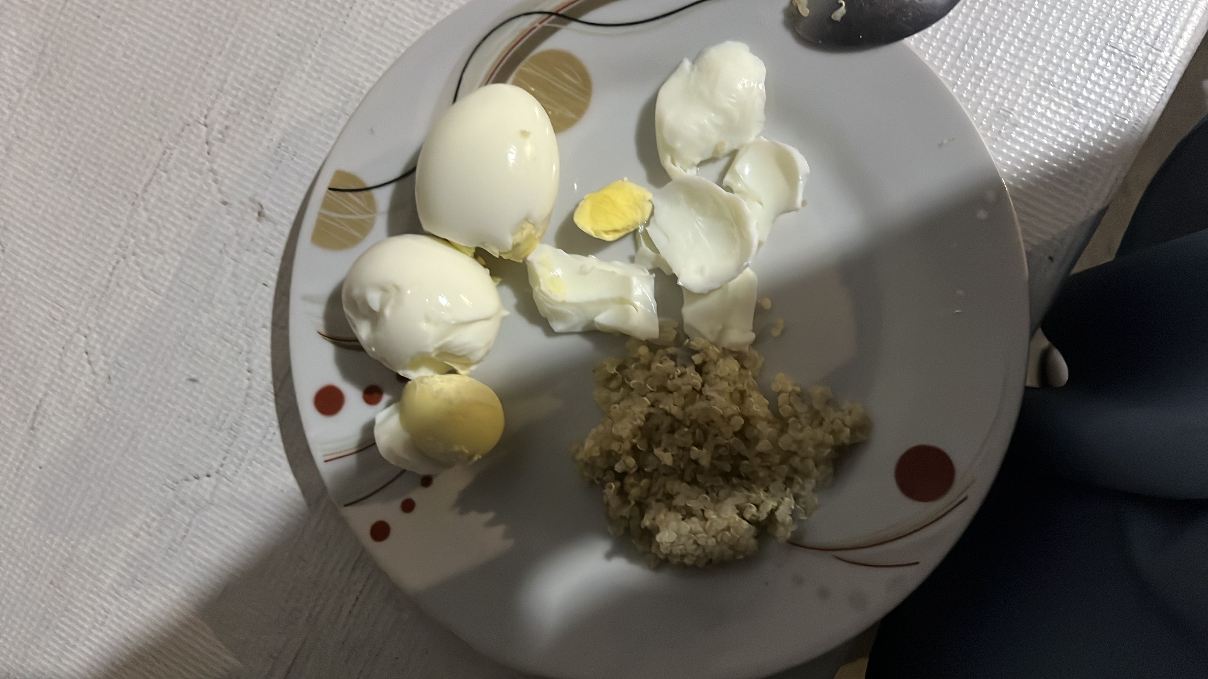 A plate containing boiled eggs and quinoa, providing a balanced mix of protein, carbs, and fats.