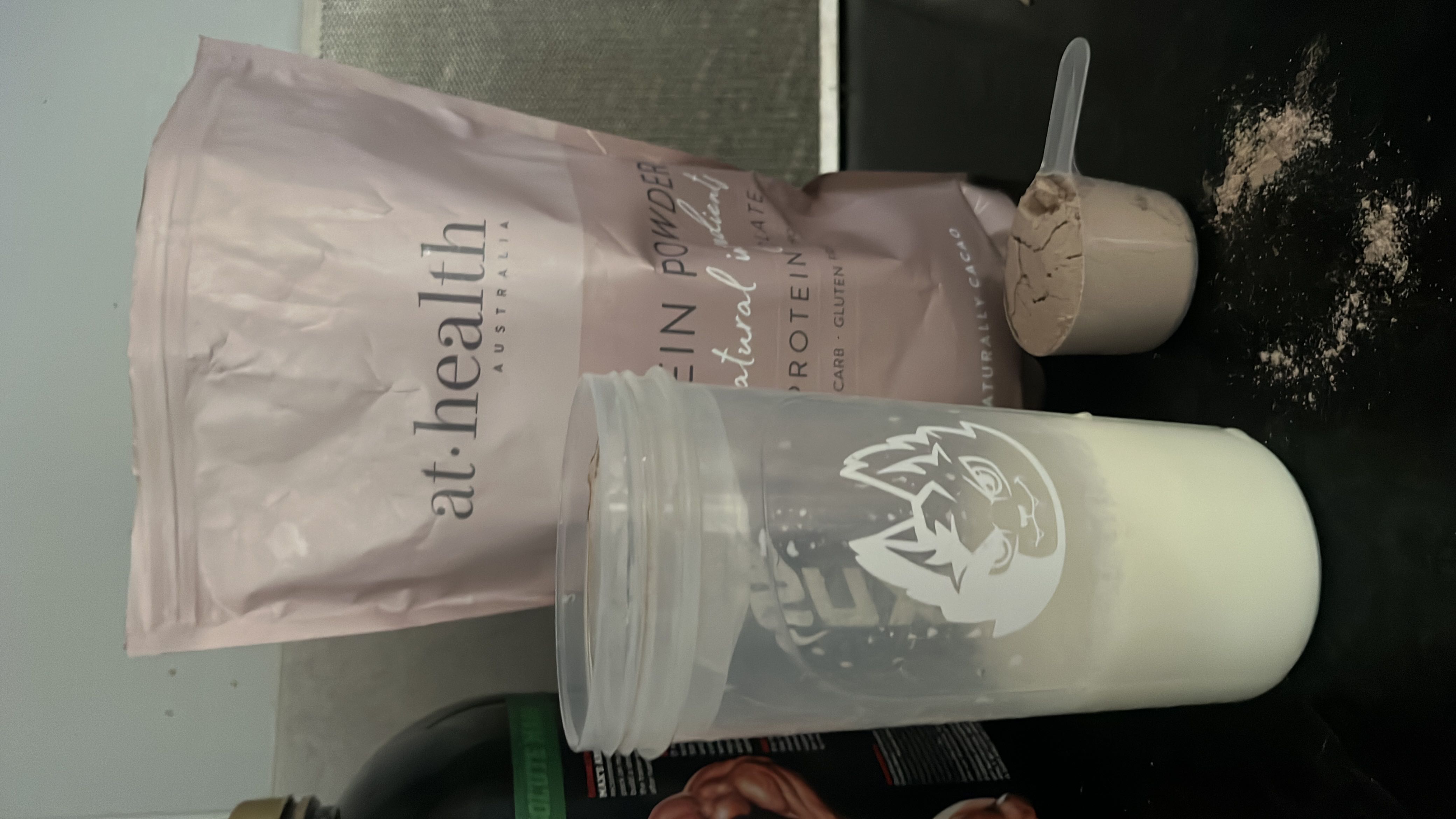 The image shows a protein powder product with a scoop and a shaker bottle, indicating a low-calorie, high-protein supplement suitable for fitness and health enthusiasts.