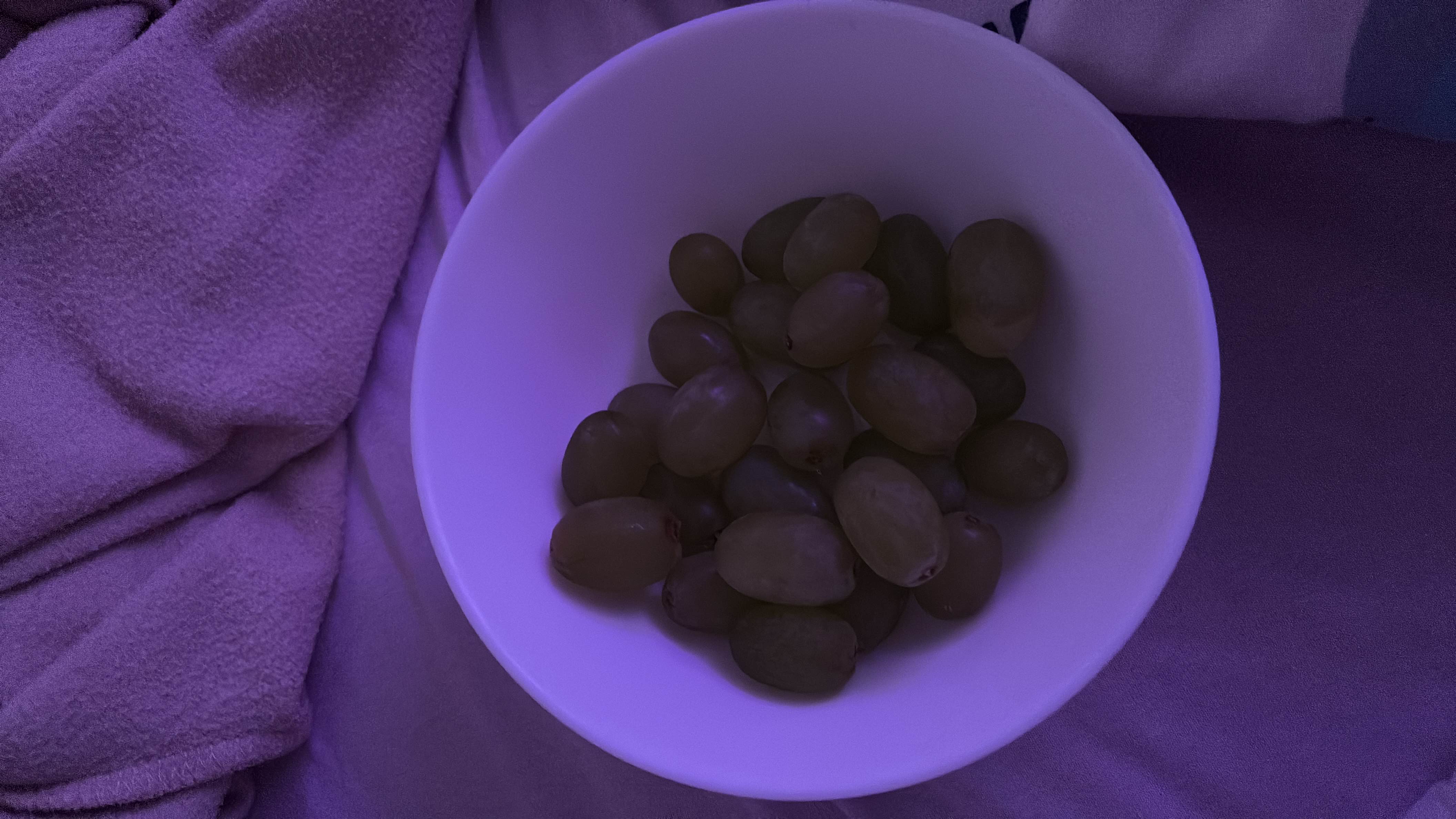 A bowl of grapes, a low-calorie fruit rich in carbohydrates and minimal fats, providing a healthy snack option.