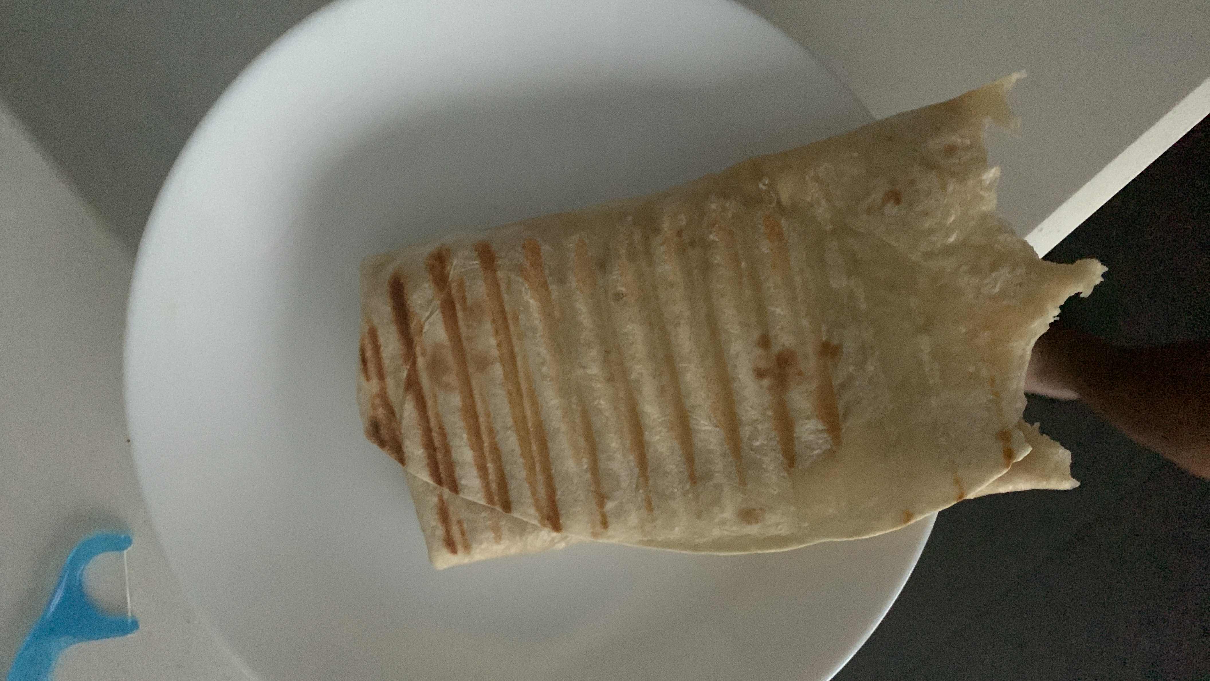 A grilled wrap containing tortilla, chicken, and cheese, providing a balanced mix of protein, carbs, and fats.