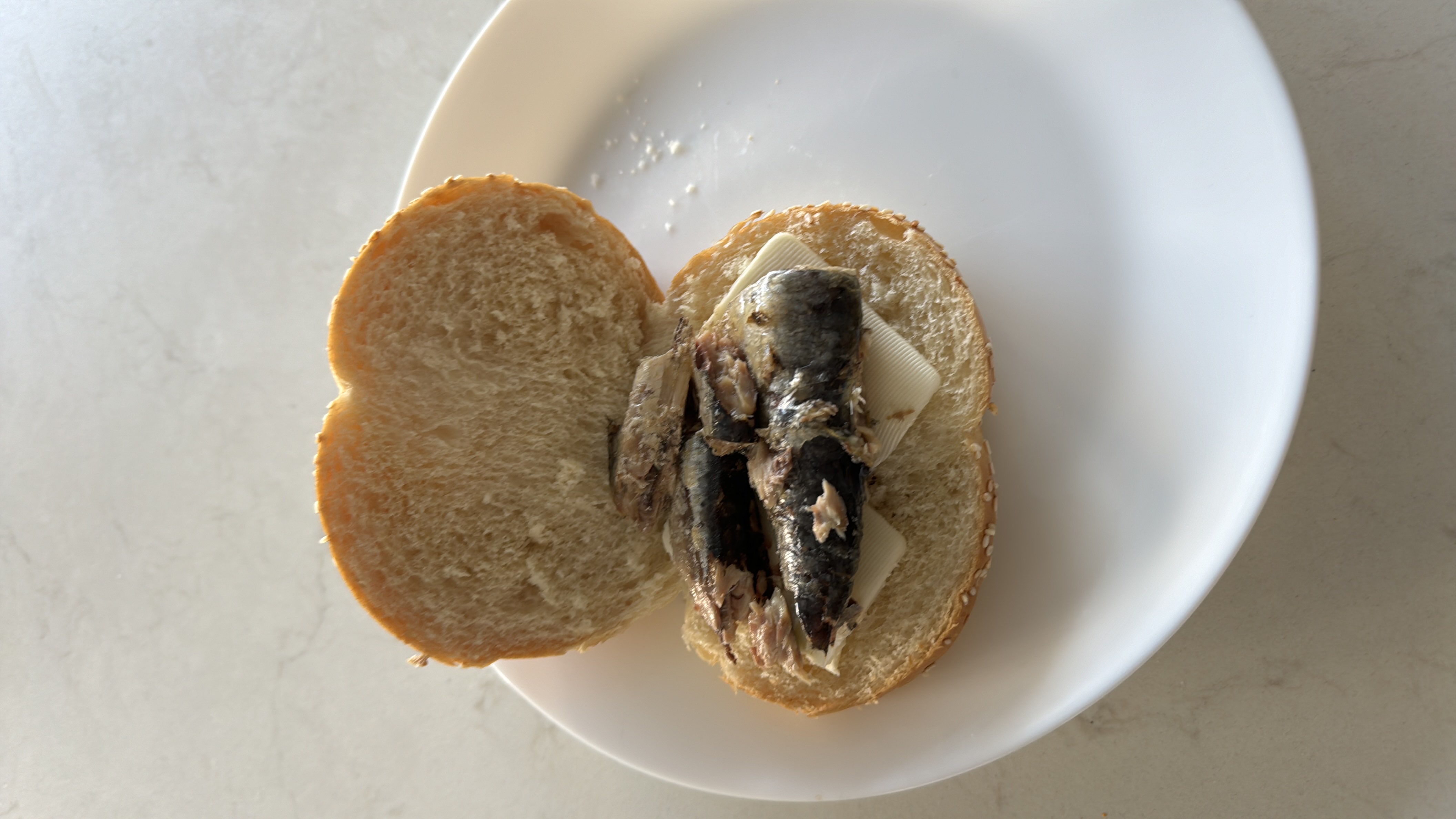 A sandwich made with bread, sardines, and butter, providing a balanced mix of protein, carbs, and fats.