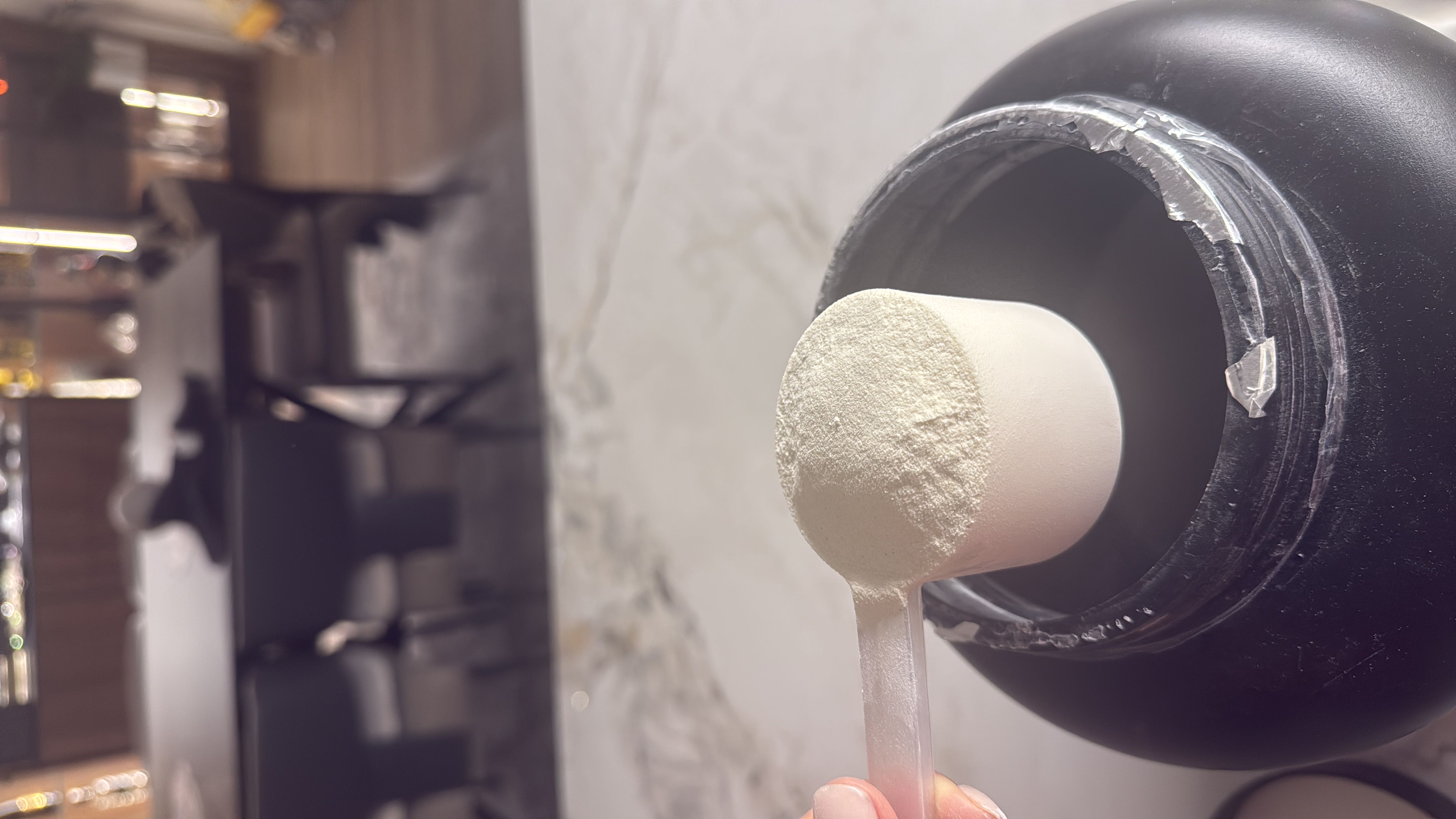 A scoop of whey protein powder, commonly used as a dietary supplement for muscle building and recovery.