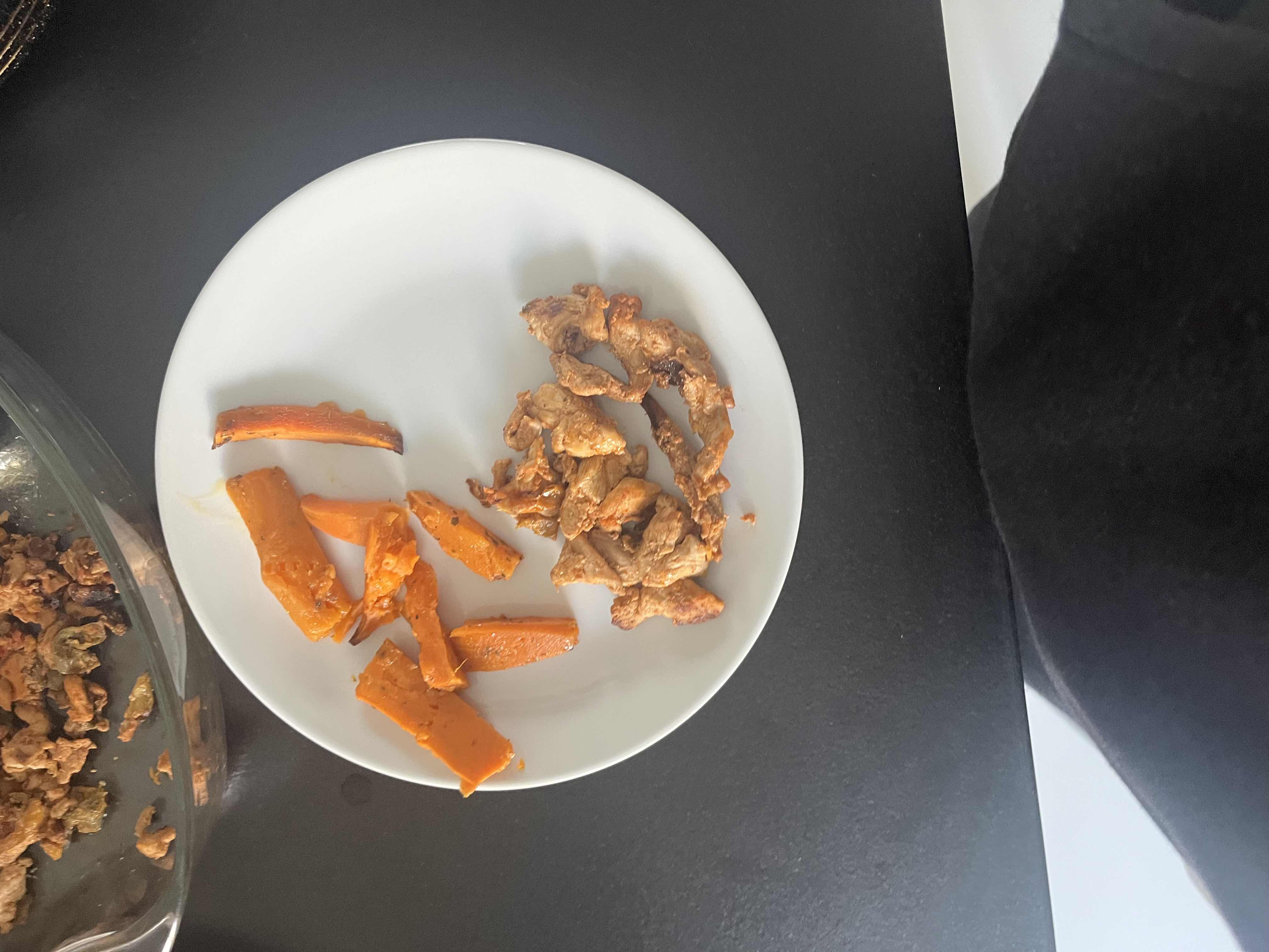 A plate containing sweet potato and chicken breast, providing a balanced mix of protein, carbohydrates, and fats.