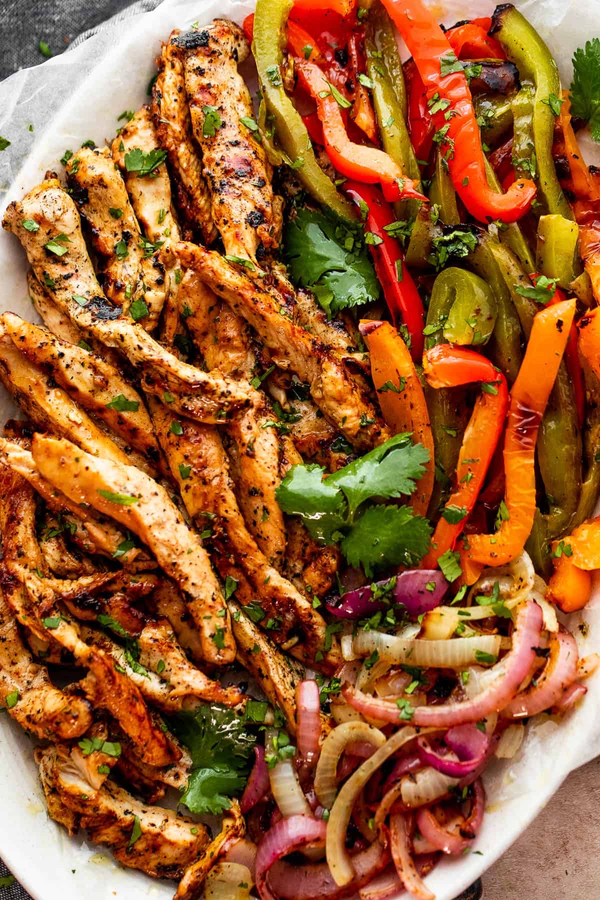 A healthy dish featuring grilled chicken strips, sautéed bell peppers, and onions, seasoned with herbs and spices.