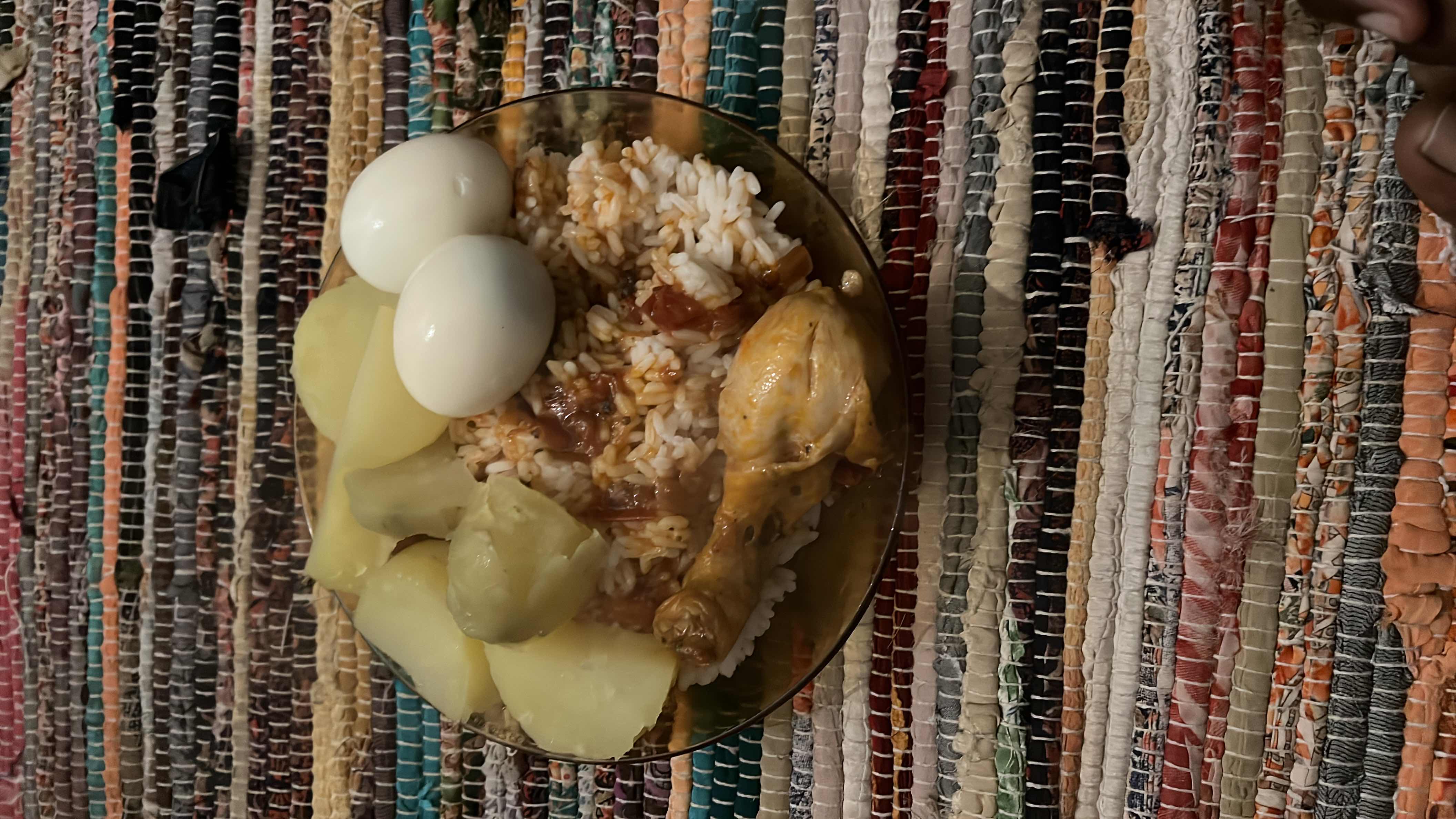 A balanced meal consisting of boiled eggs, boiled potatoes, white rice, and a chicken drumstick, providing a mix of protein, carbohydrates, and fats.