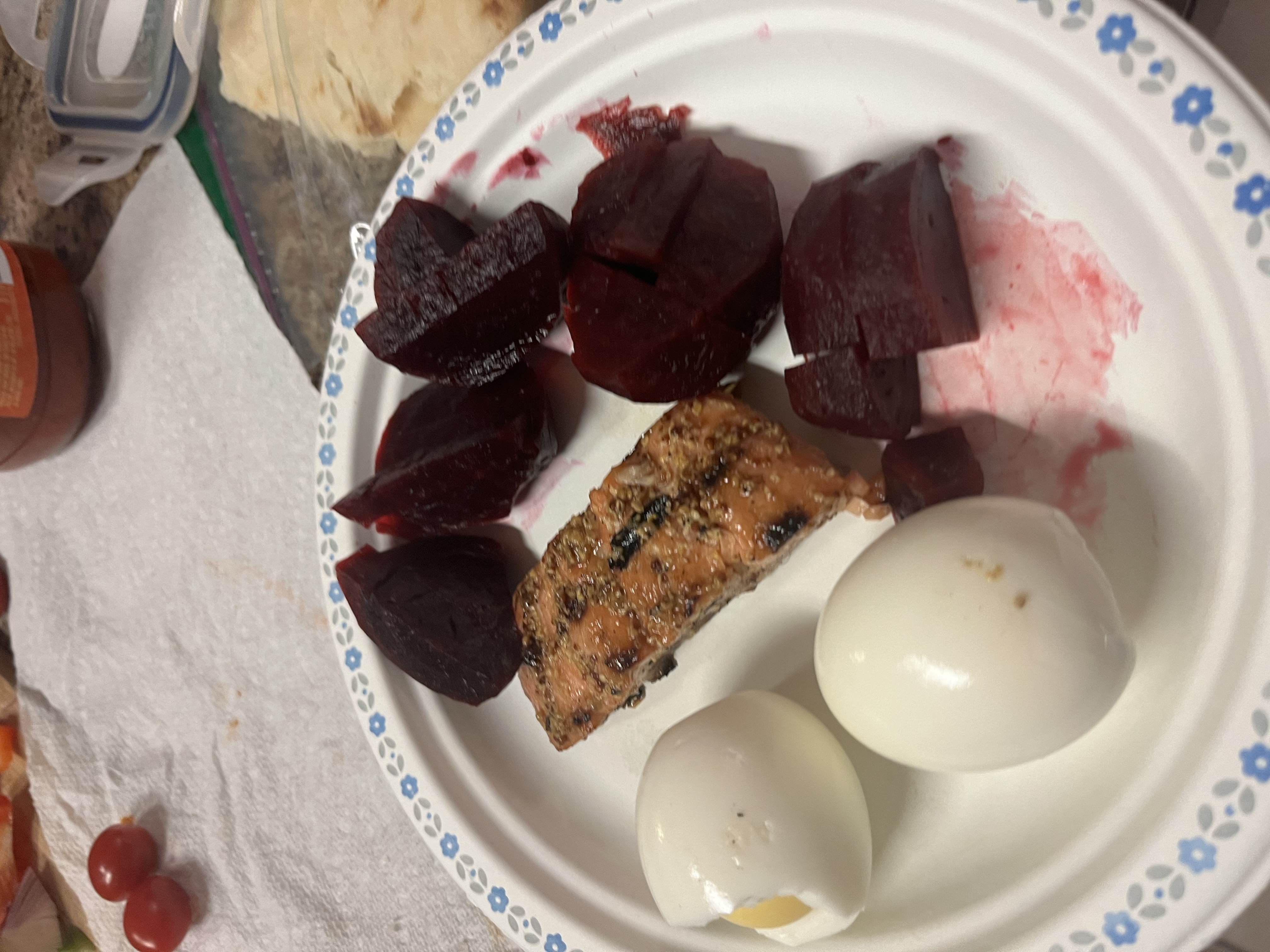 A balanced meal consisting of boiled eggs, grilled salmon, and beets, providing a good mix of protein, healthy fats, and carbohydrates.