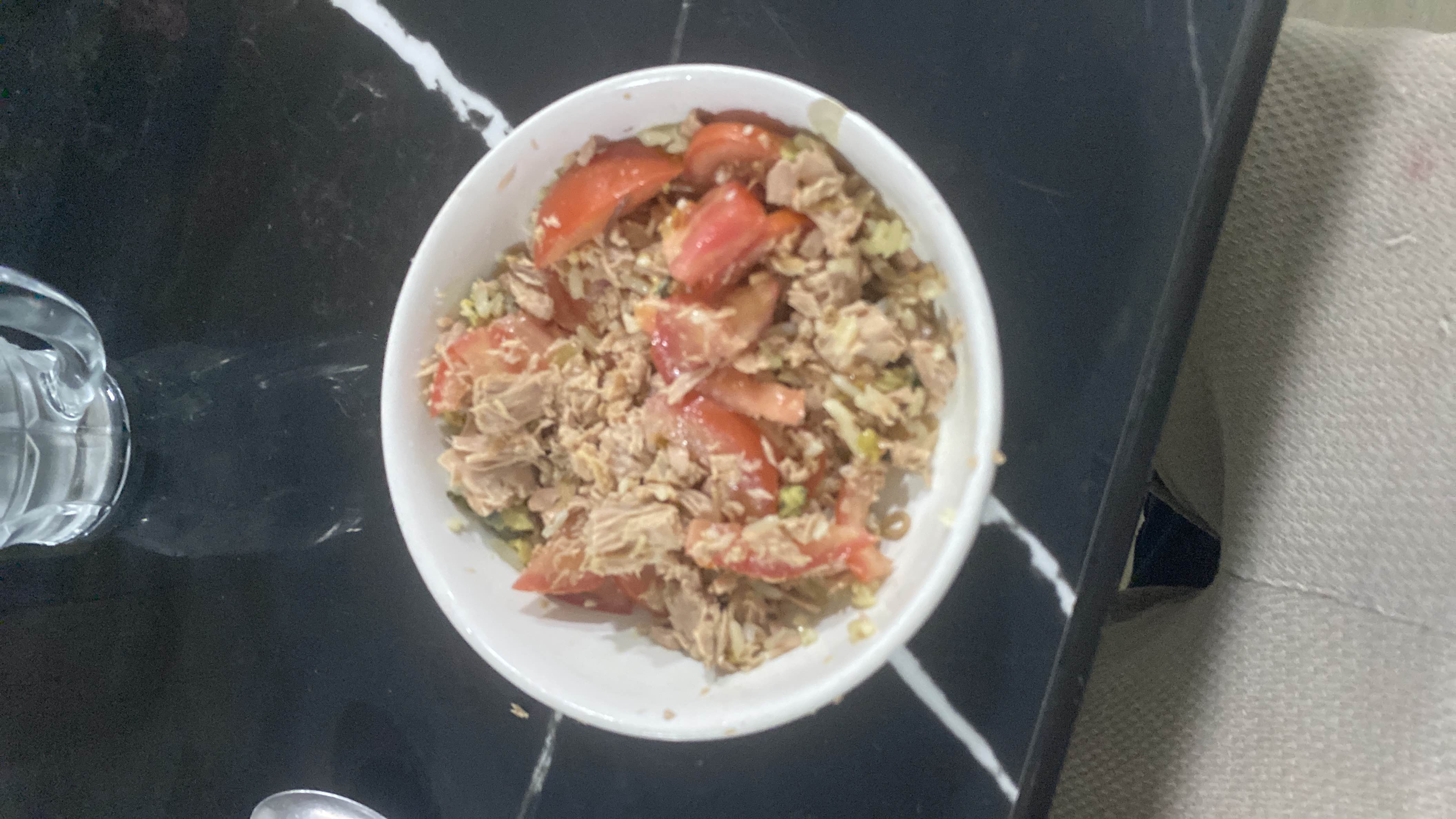 A bowl of tuna salad with tomatoes and rice, providing a balanced mix of protein, carbs, and fats.
