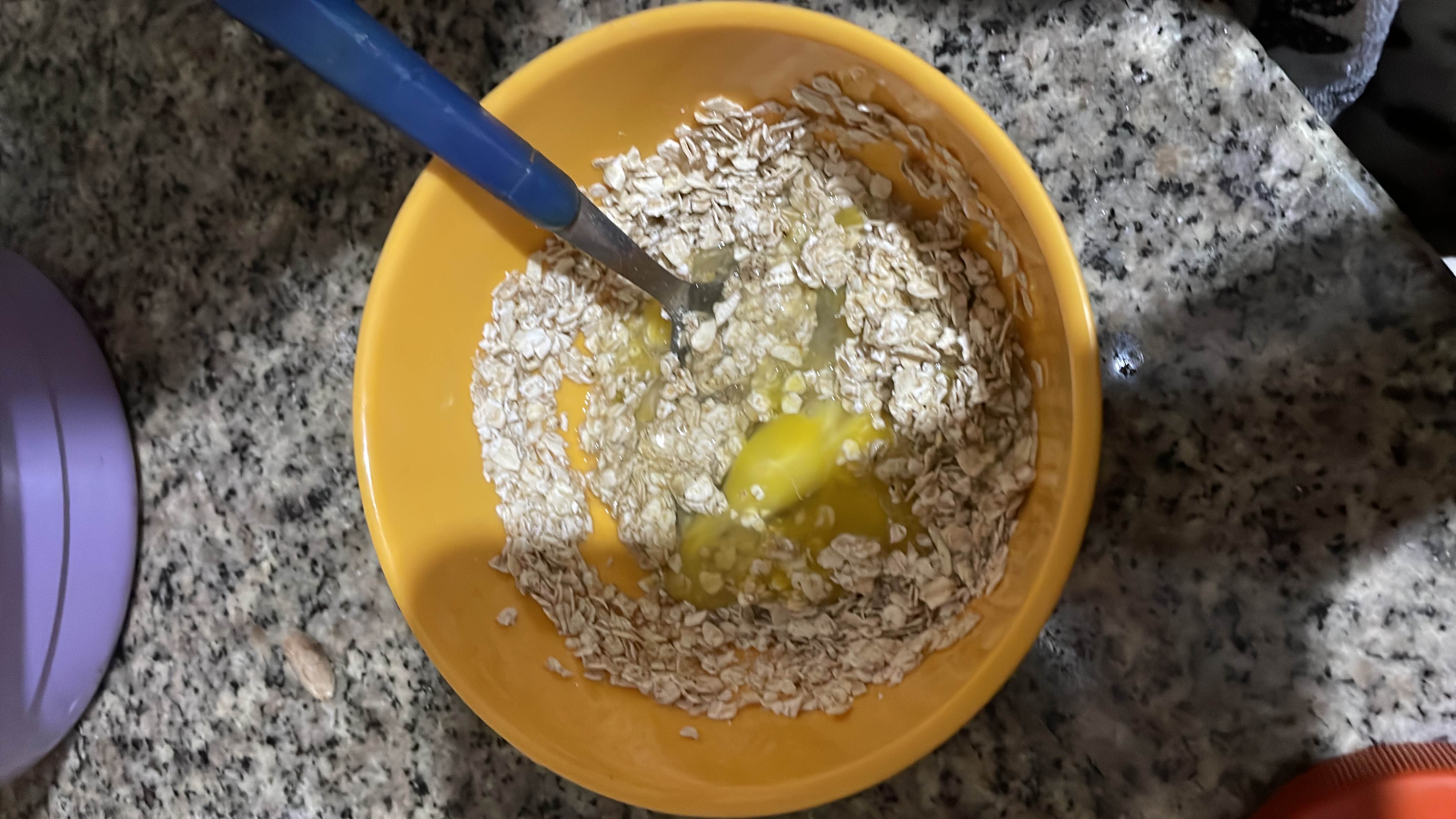A bowl containing oats mixed with an egg and water, providing a balanced mix of protein, carbs, and fats.
