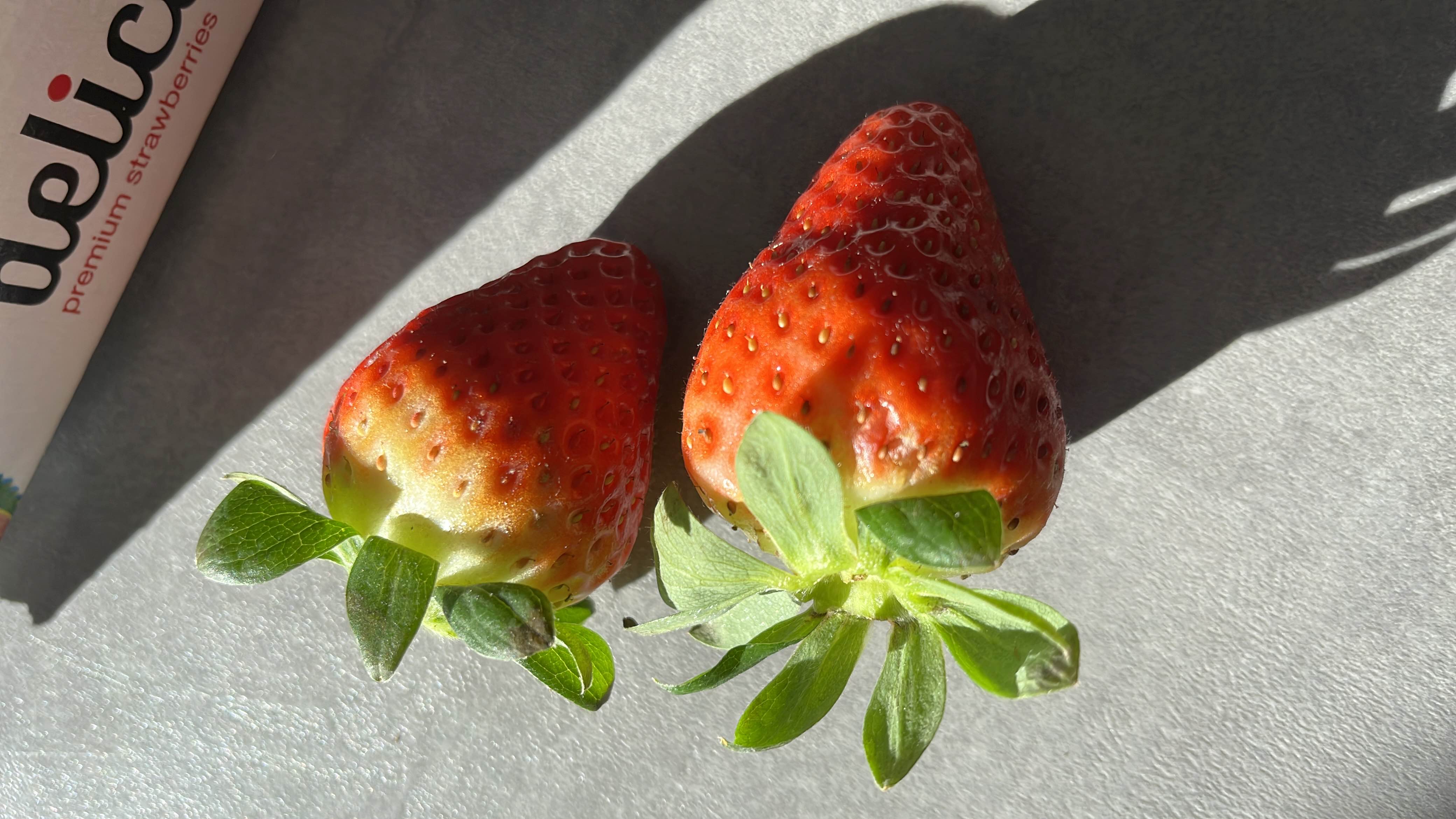 The image shows fresh strawberries, which are low-calorie fruits rich in vitamins and antioxidants.