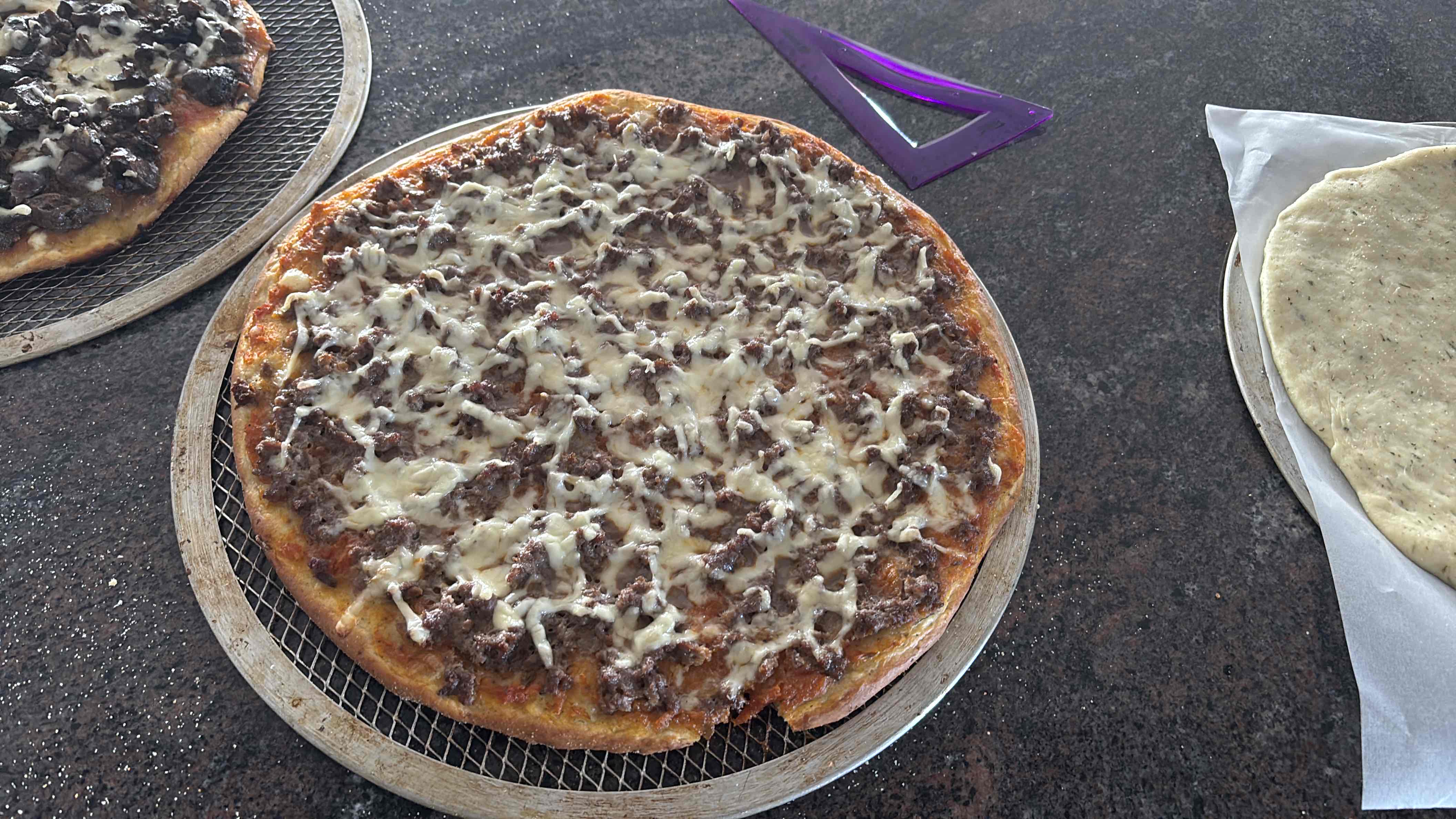 A homemade pizza topped with ground beef and melted cheese on a baked crust.
