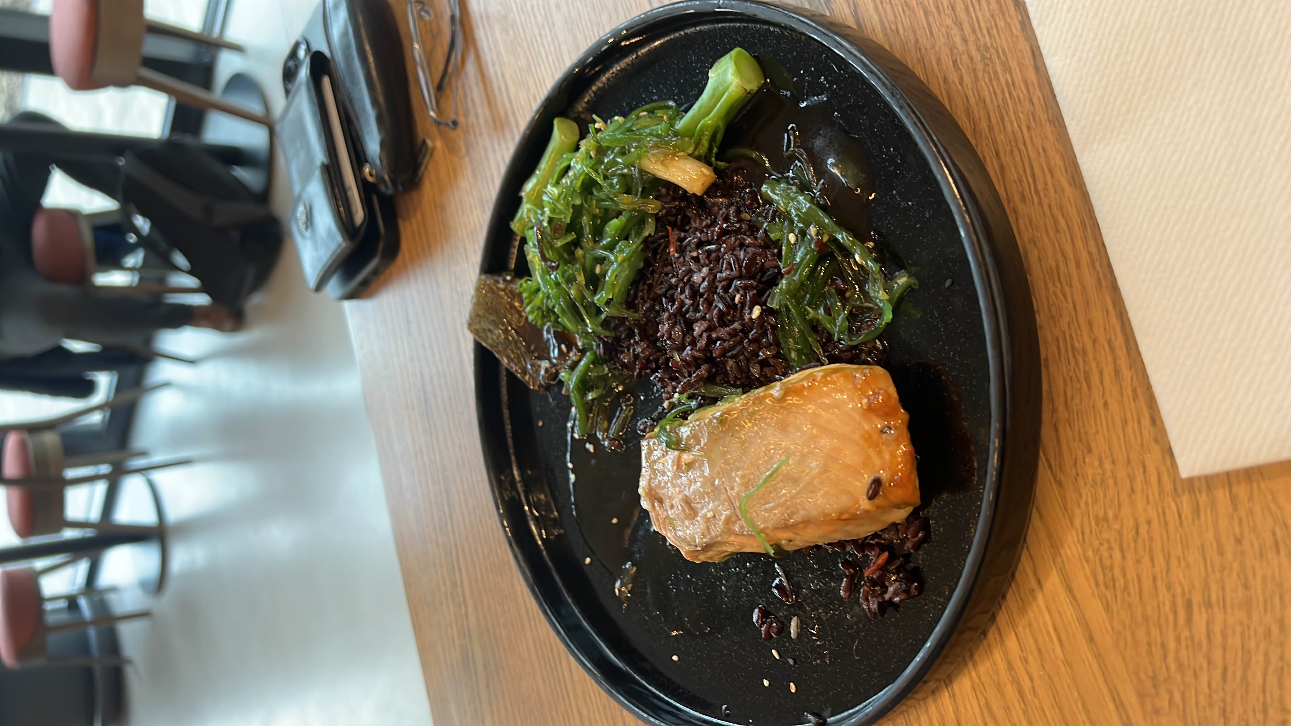 A nutritious dish featuring salmon, black rice, seaweed, and broccoli, offering a balanced mix of protein, carbs, and healthy fats.