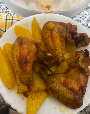 The dish consists of roasted chicken wings and potato wedges, providing a balanced mix of protein, carbs, and fats.