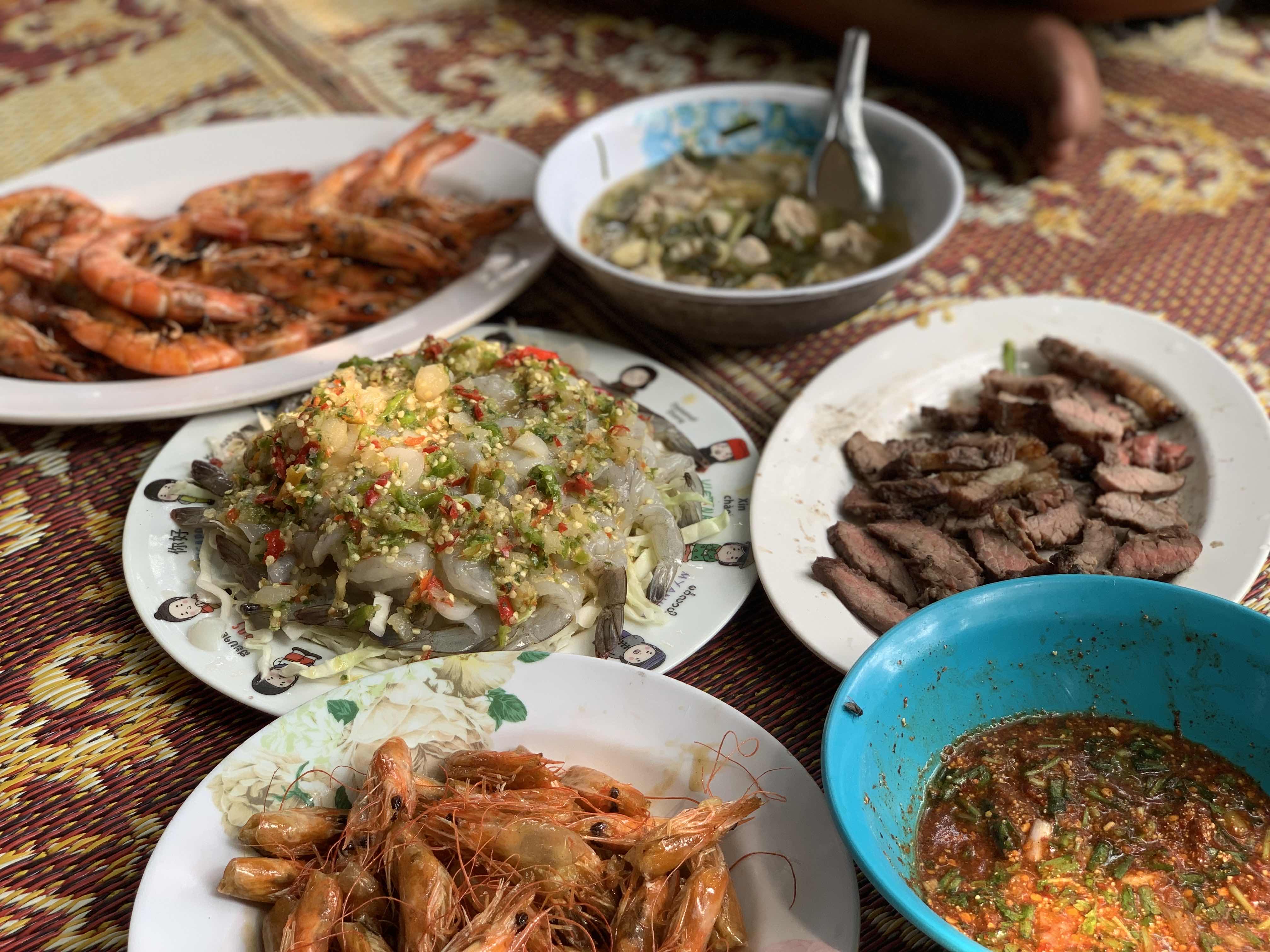 A variety of dishes including grilled shrimp, spicy shrimp salad, grilled beef slices, vegetable soup, and a spicy dipping sauce, offering a balanced mix of protein, fats, and carbs.