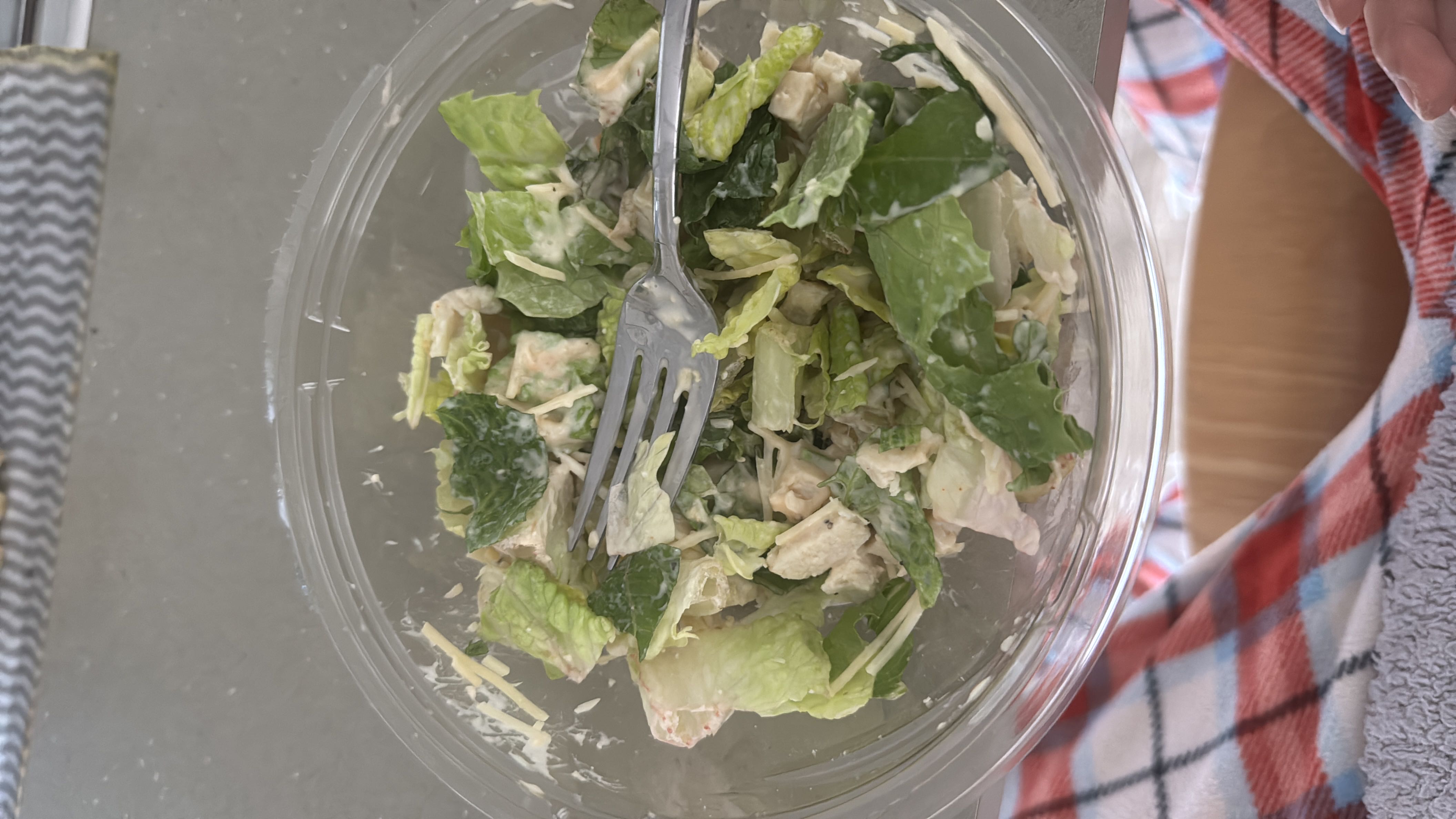 A Caesar salad with romaine lettuce, grilled chicken, Parmesan cheese, and Caesar dressing.