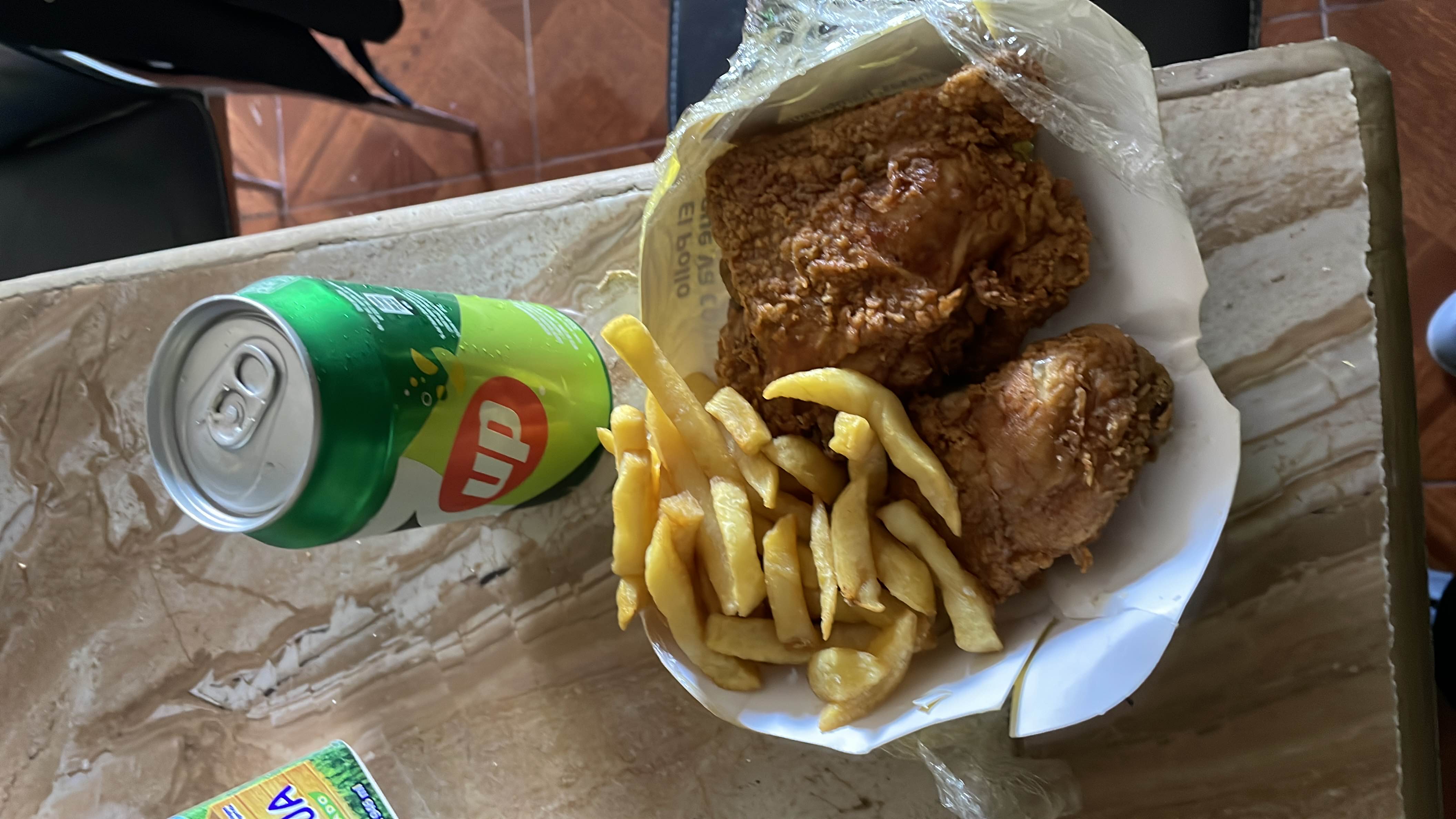 A meal consisting of fried chicken, french fries, and a can of soda, providing a high-calorie intake with moderate protein and high fat and carbohydrate content.