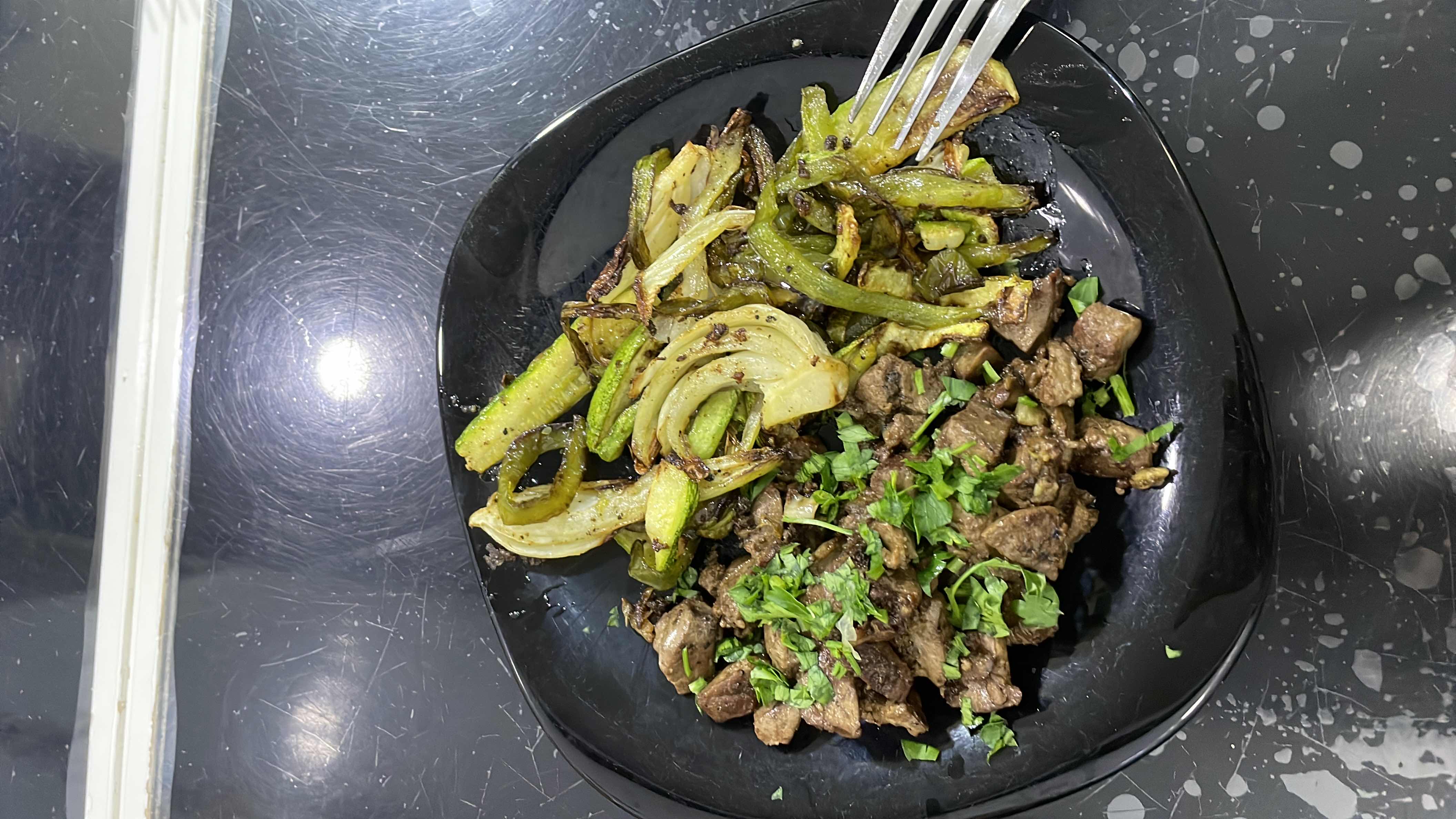 A nutritious dish featuring sautéed beef liver, zucchini, onion, green pepper, and parsley, providing a balanced mix of protein, fats, and carbs.