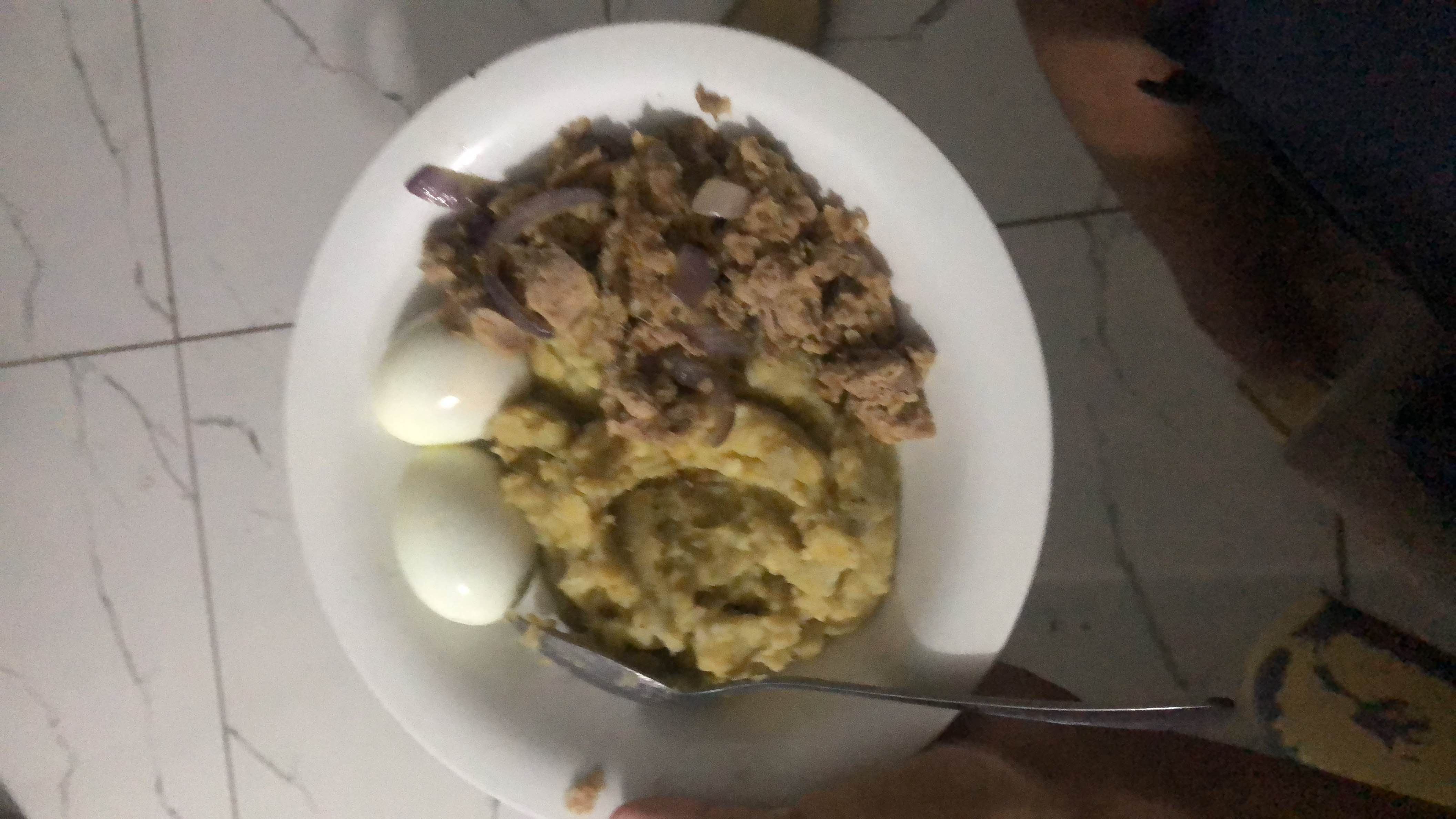 A balanced meal consisting of boiled eggs, mashed plantains, and stewed meat, providing a good mix of protein, carbohydrates, and fats.