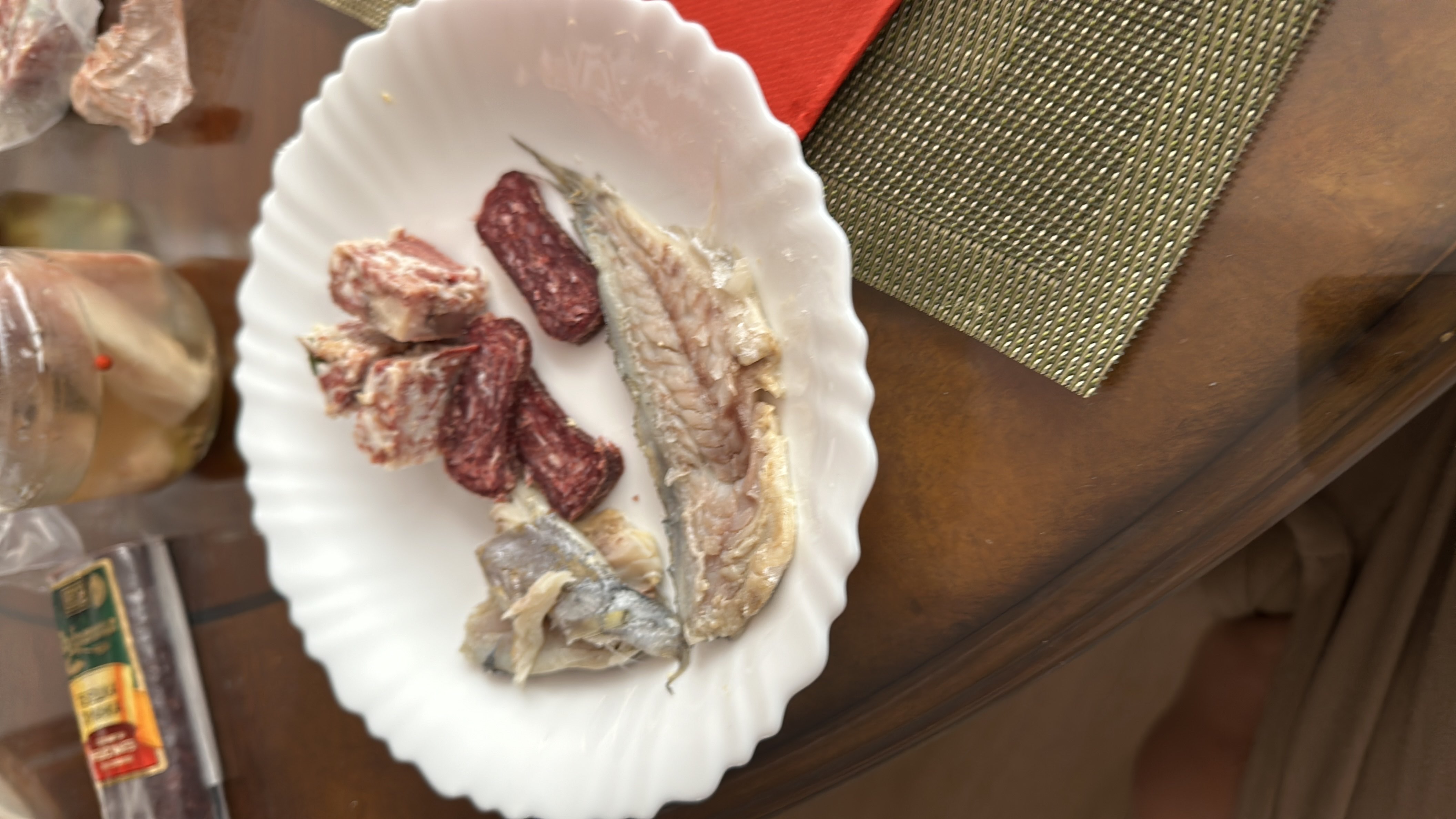 A plate containing smoked fish, cured sausage, and veal, providing a high-protein and high-fat meal with minimal carbohydrates.