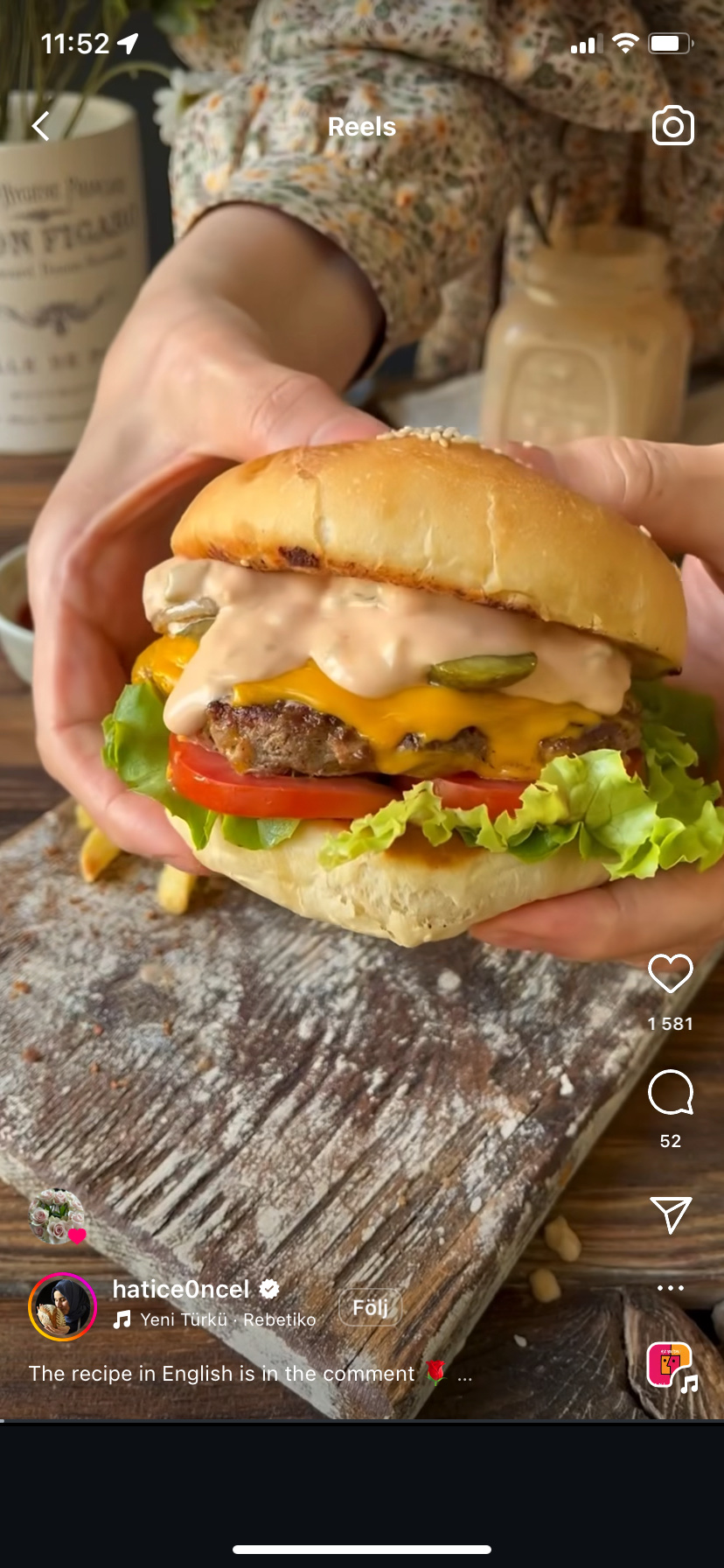 A classic cheeseburger with a beef patty, cheddar cheese, lettuce, tomato, pickles, and sauce, served in a burger bun.