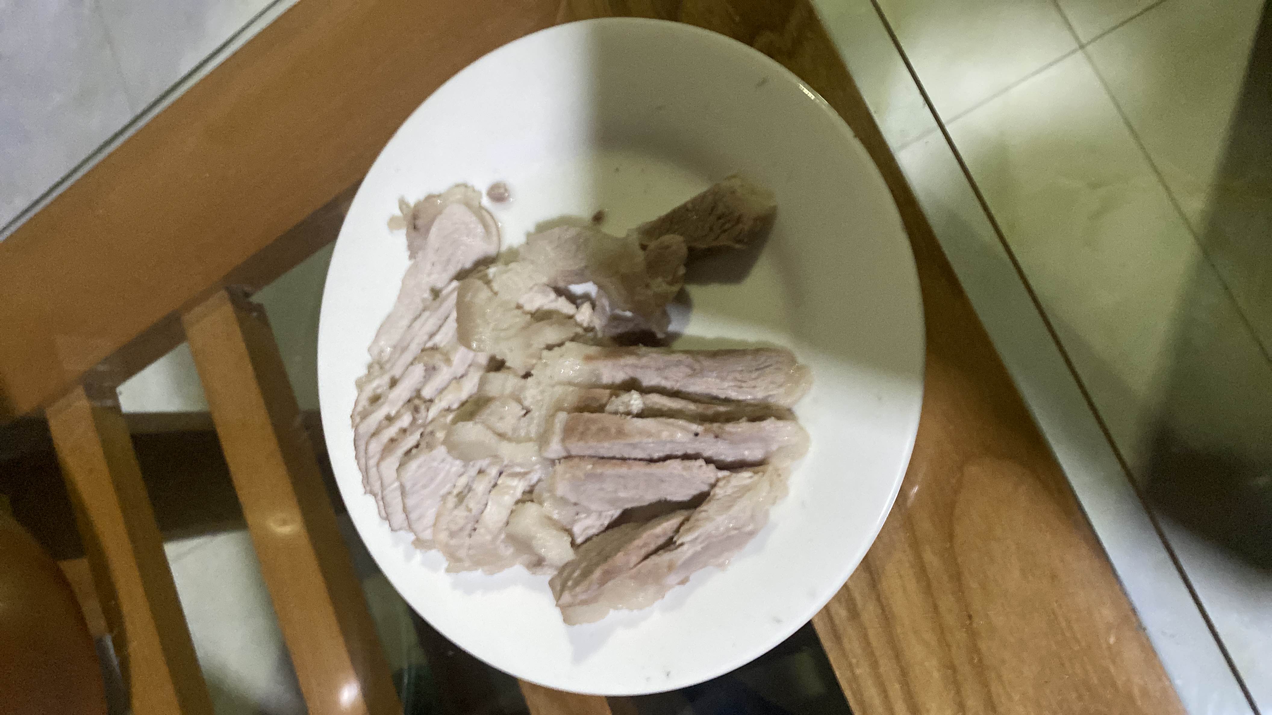 The image shows a plate of boiled pork slices, which are high in protein and fats with no carbohydrates.