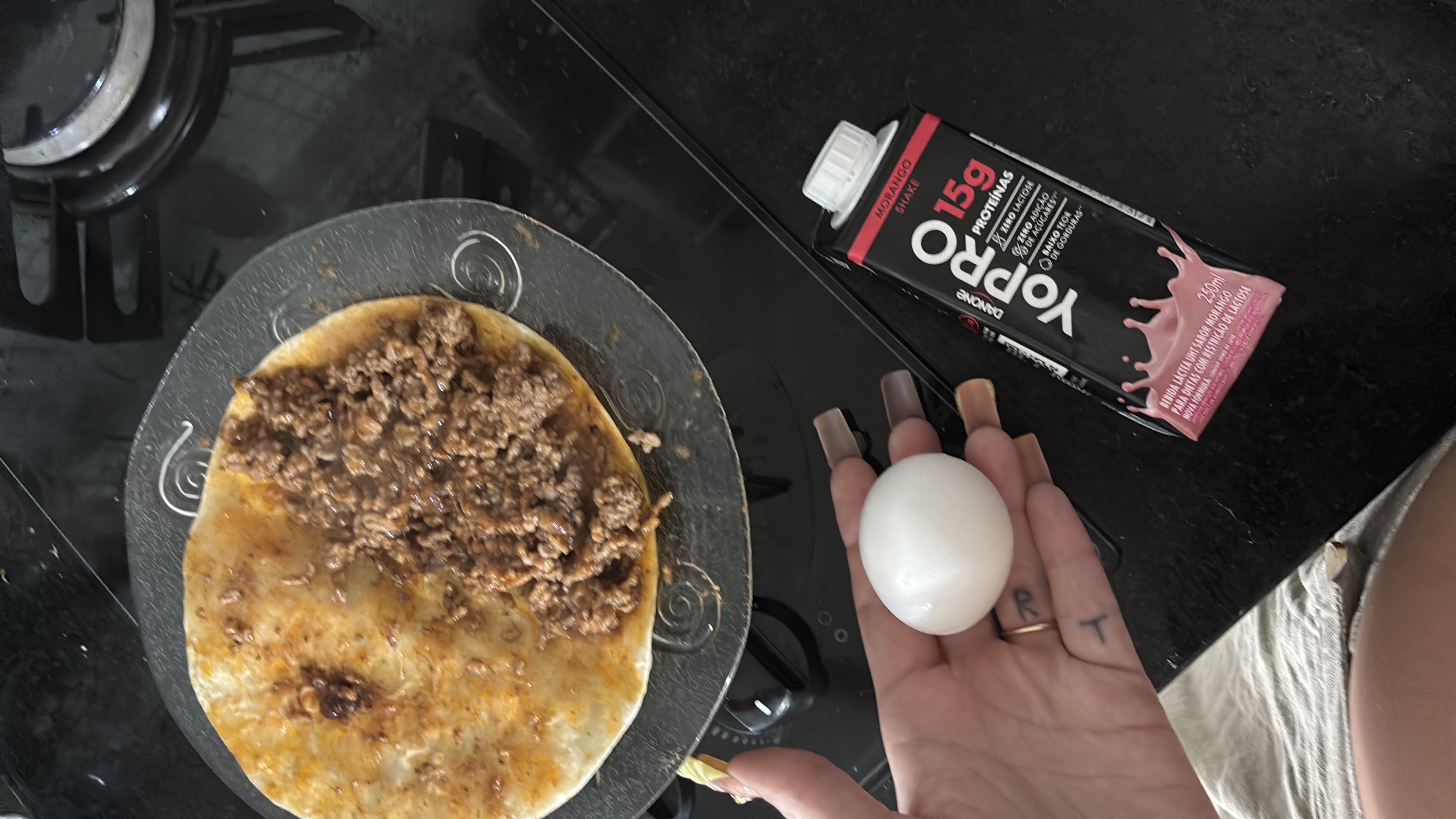 A meal consisting of a tortilla with ground beef, a boiled egg, and a YoPRO protein shake, providing a balanced mix of protein, carbs, and fats.