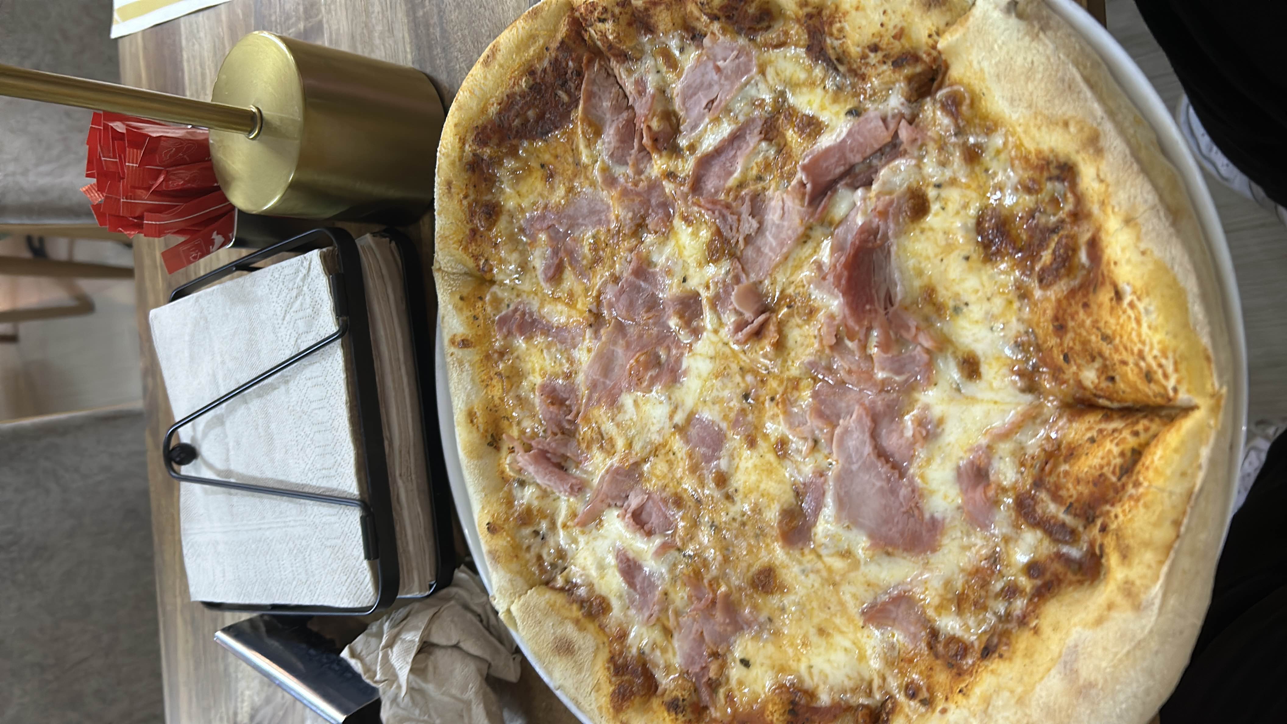 A ham and cheese pizza with a crispy crust, topped with tomato sauce and melted cheese.