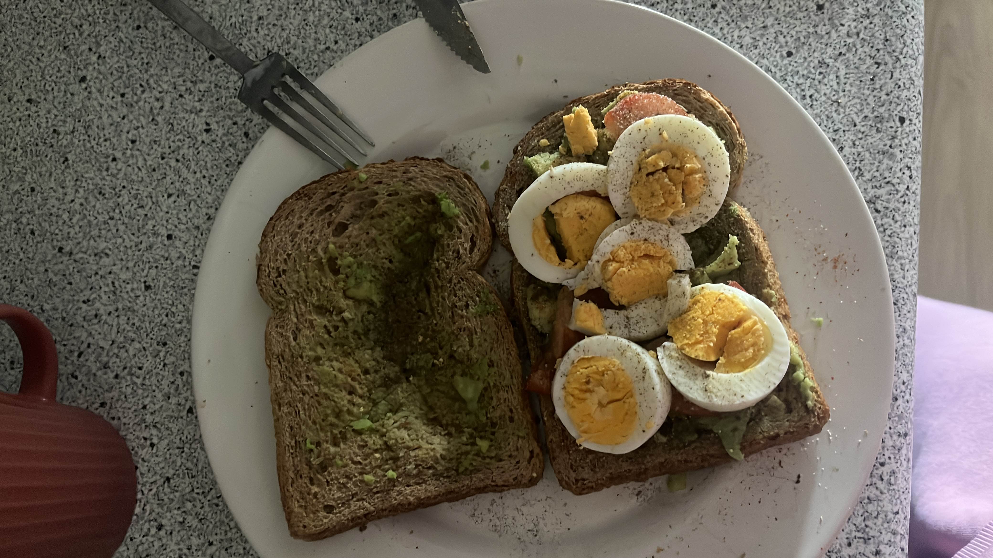 A healthy sandwich made with whole grain bread, avocado, boiled eggs, and tomato slices, providing a balanced mix of protein, carbs, and fats.