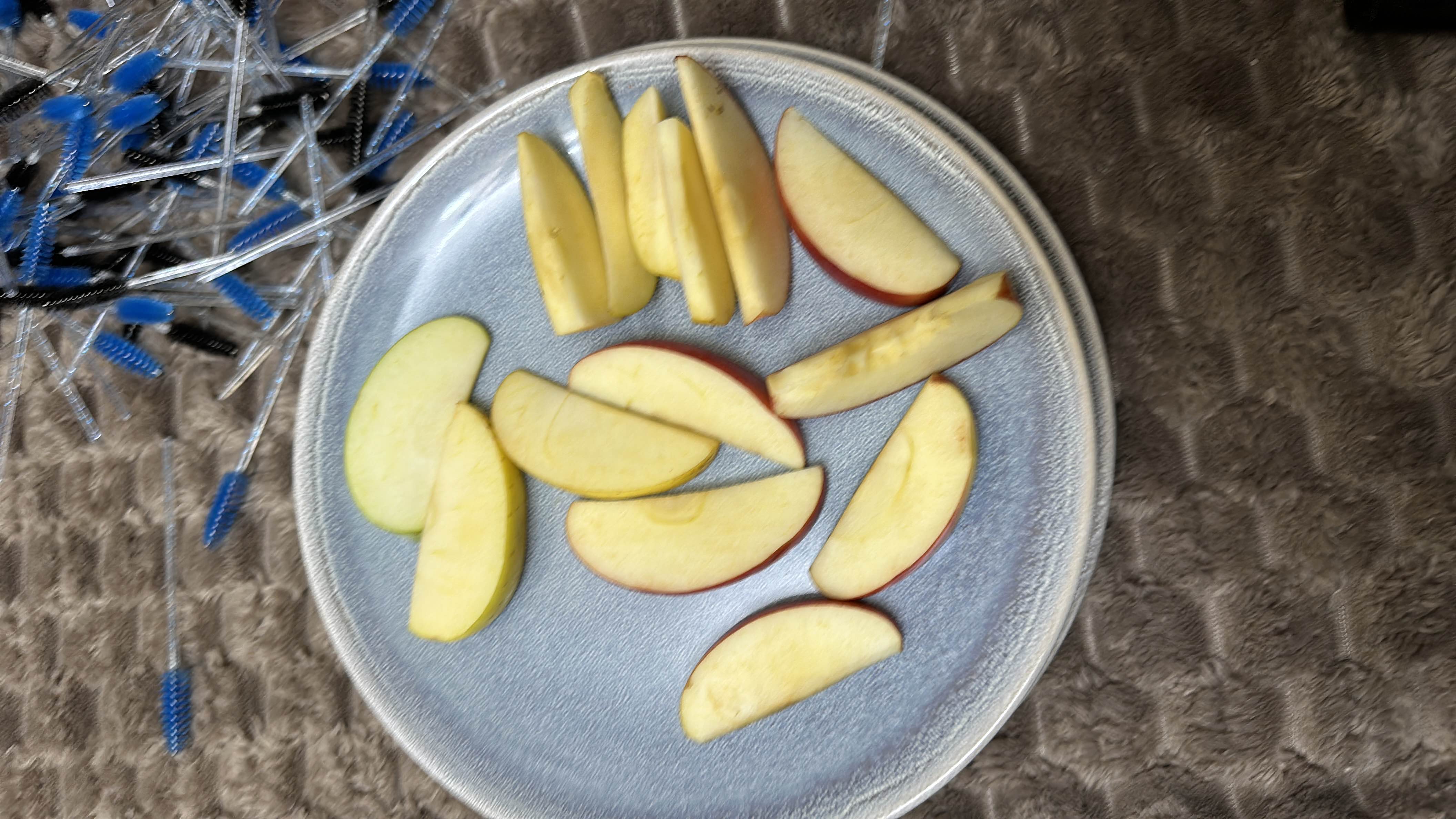 The image shows a plate of fresh apple slices, which are a healthy snack option rich in carbohydrates and low in fats and protein.
