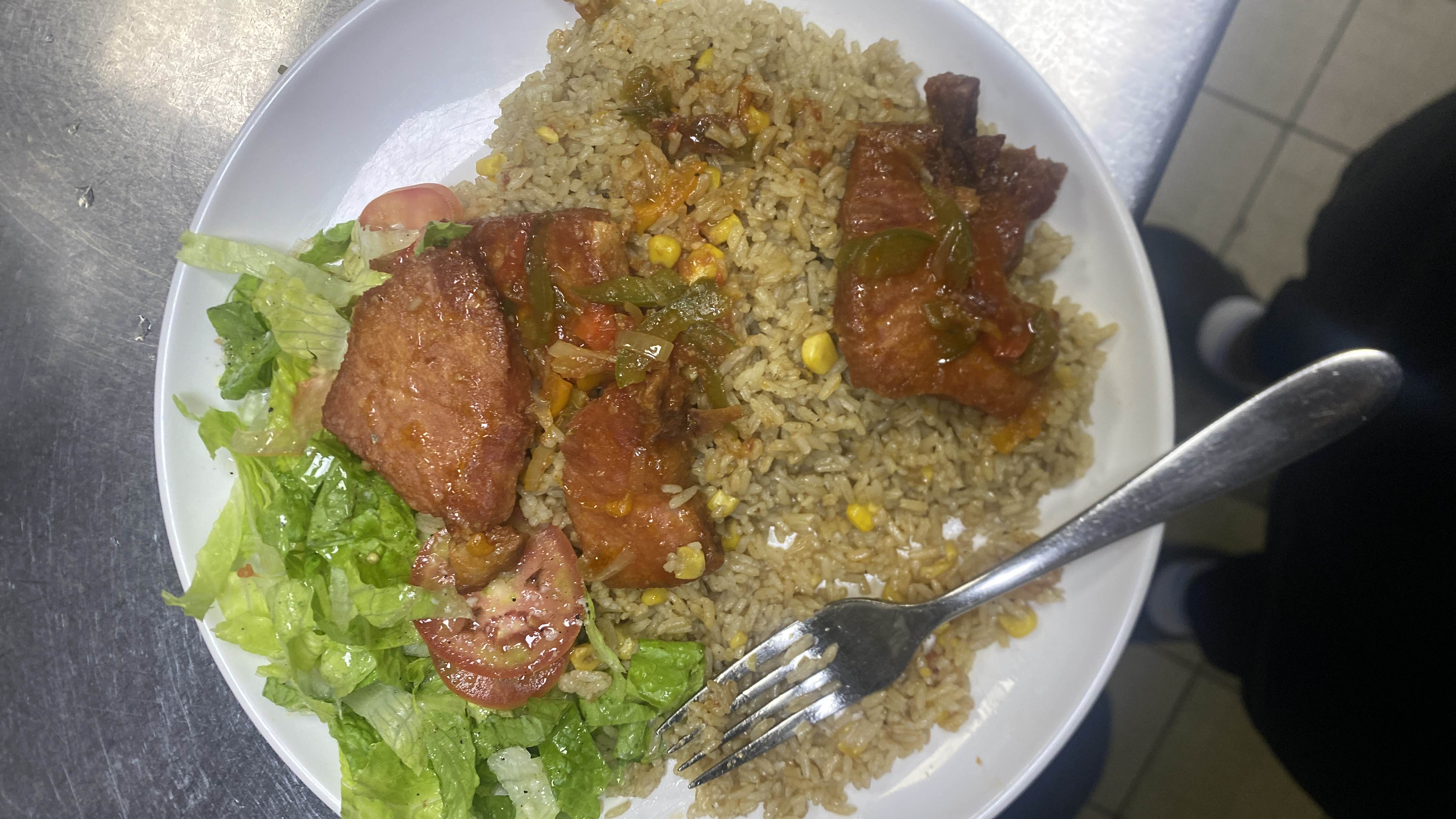 A balanced meal consisting of fried rice, grilled meat, and a fresh salad.