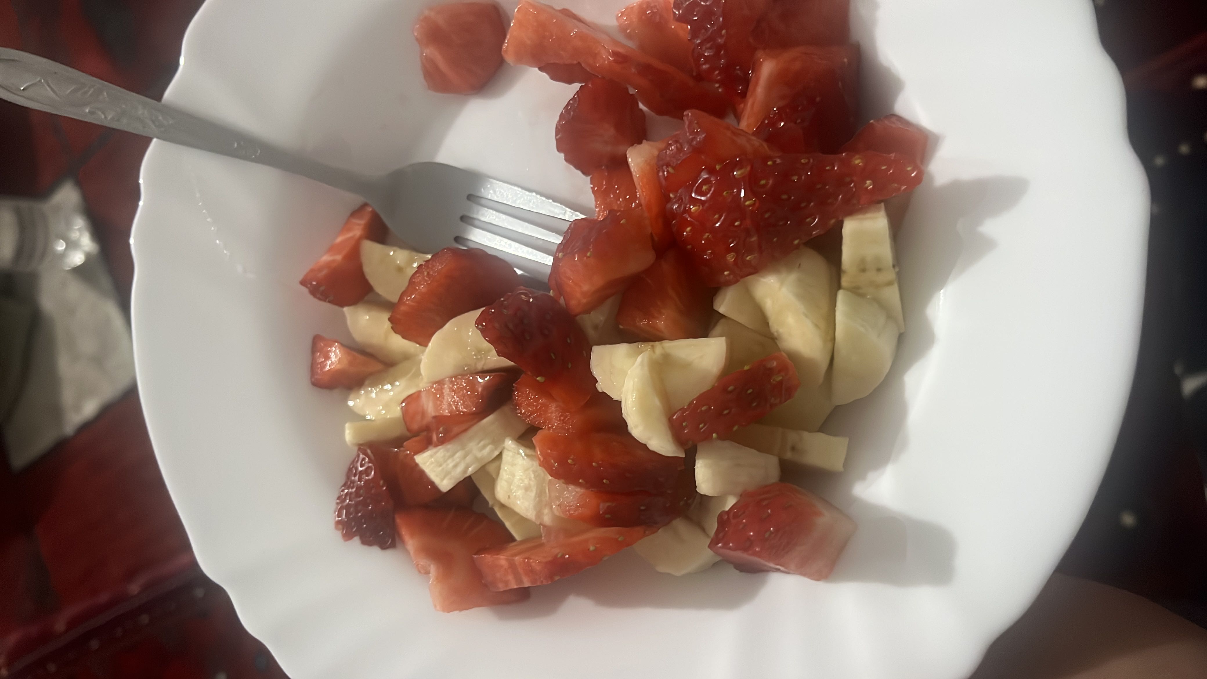 A fresh fruit salad consisting of sliced strawberries and bananas, providing a healthy and nutrient-rich snack.