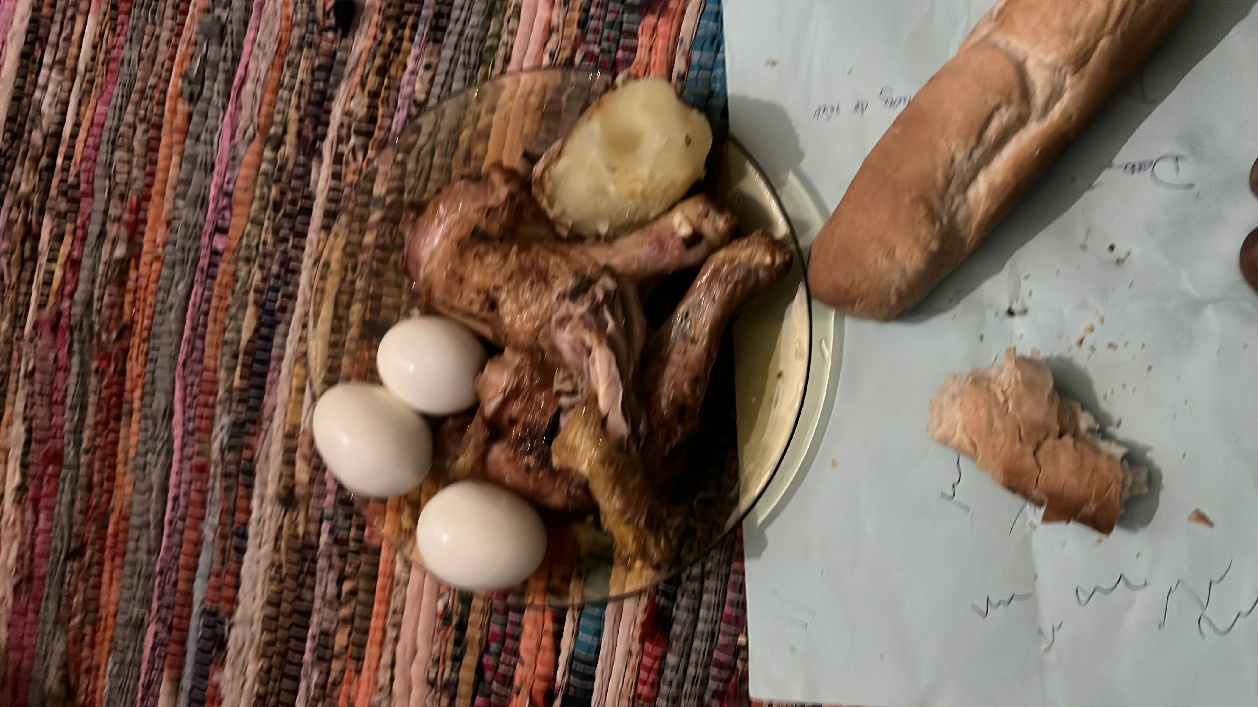 A meal consisting of boiled eggs, roasted chicken, a boiled potato, and bread, providing a balanced mix of protein, carbs, and fats.