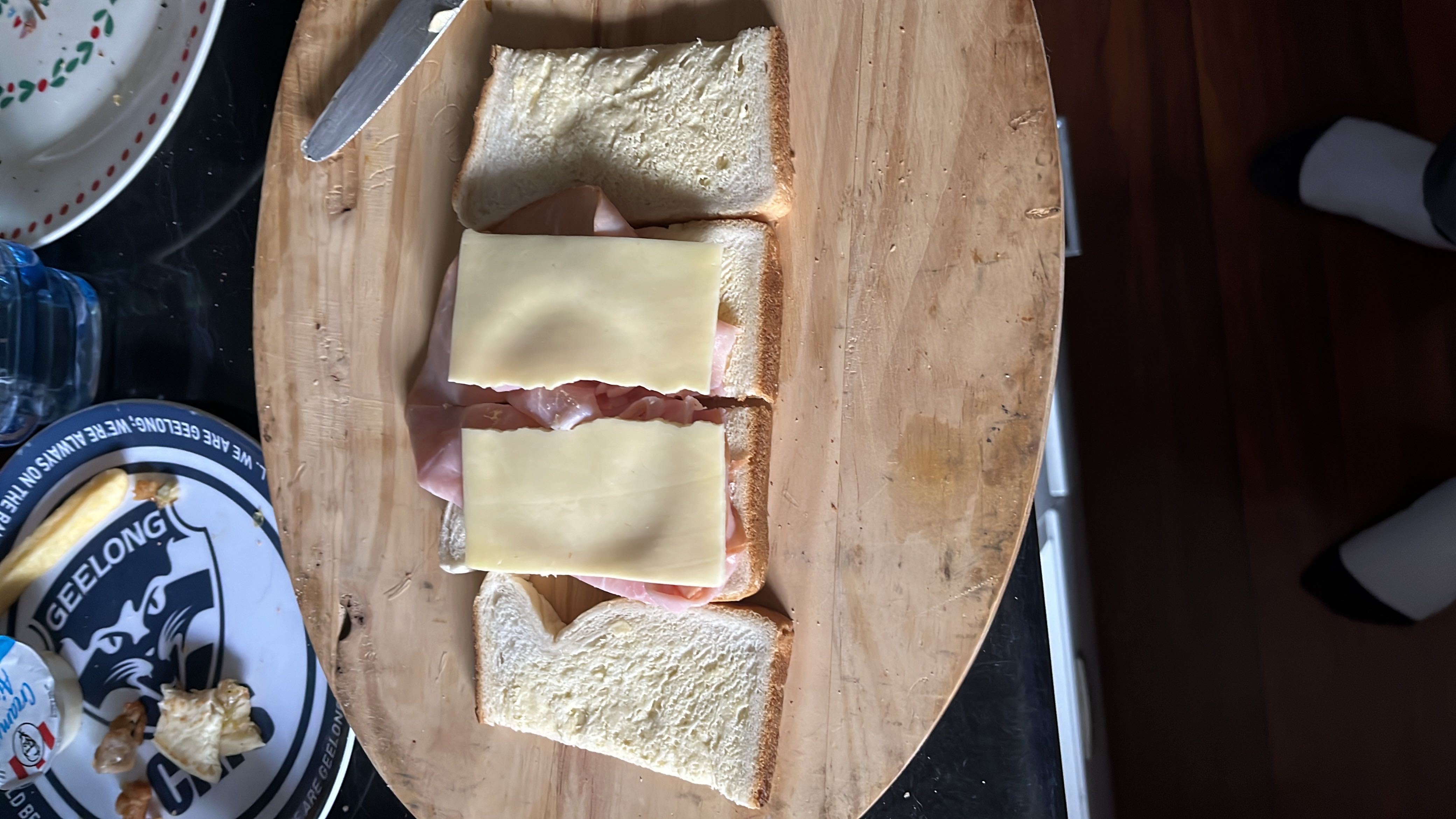 A ham and cheese sandwich made with white bread, sliced ham, and cheese slices.