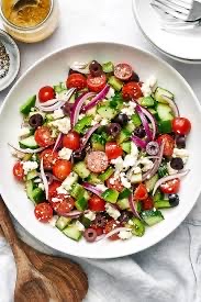 A fresh and healthy Mediterranean salad with tomatoes, cucumbers, feta cheese, olives, and red onions.