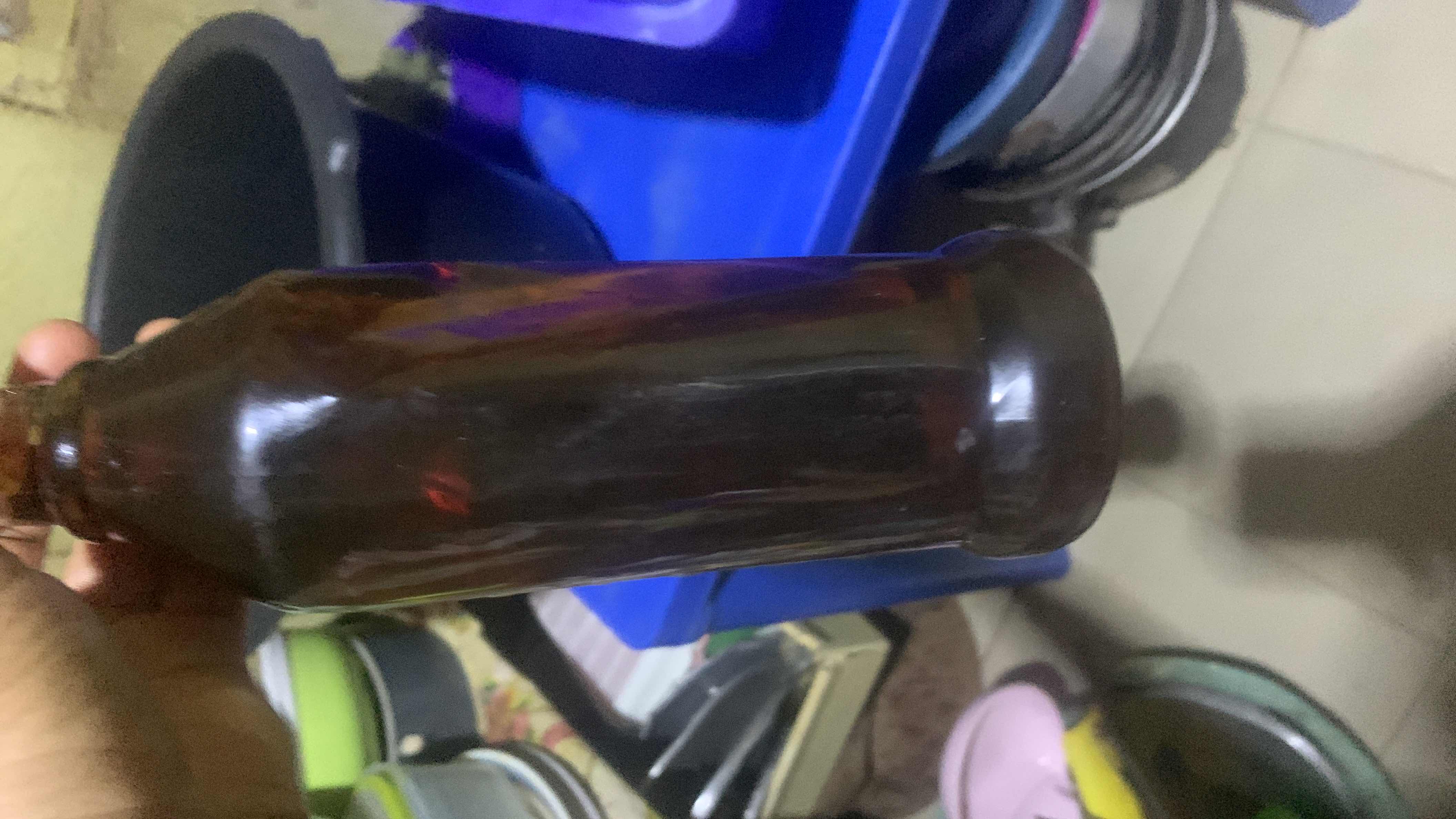 The image shows a dark-colored bottle with no visible nutritional information or labels.