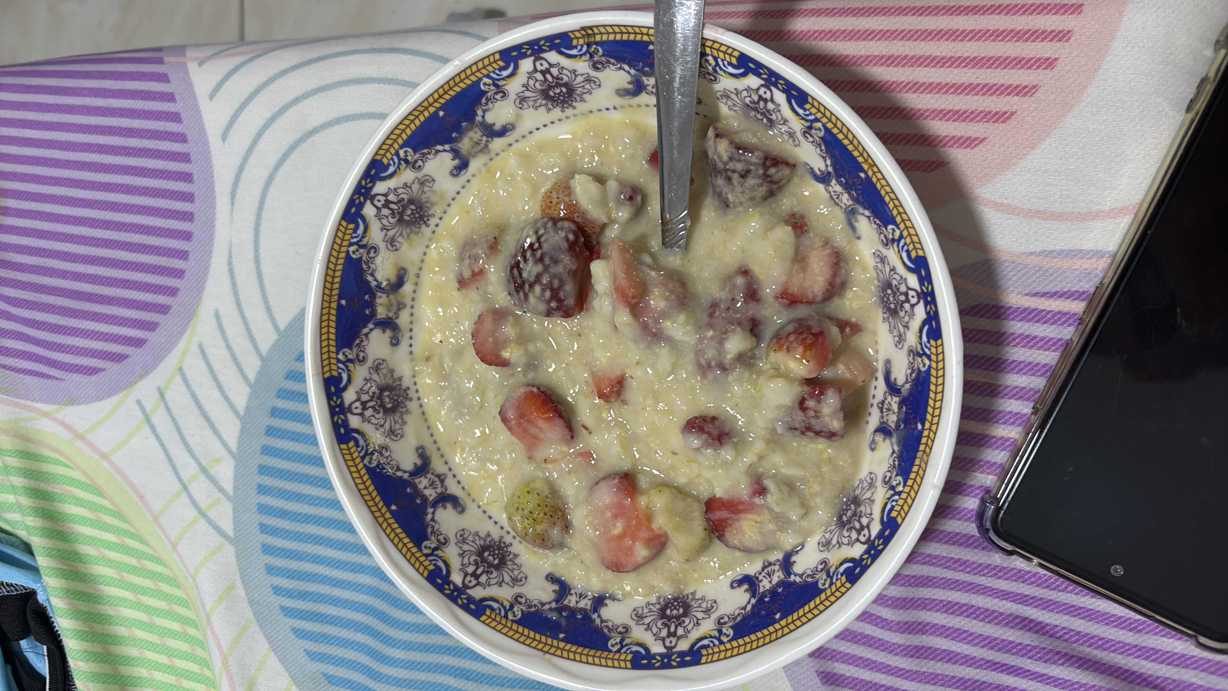 A bowl of oatmeal with strawberries and milk, providing a balanced mix of carbohydrates, protein, and fats.