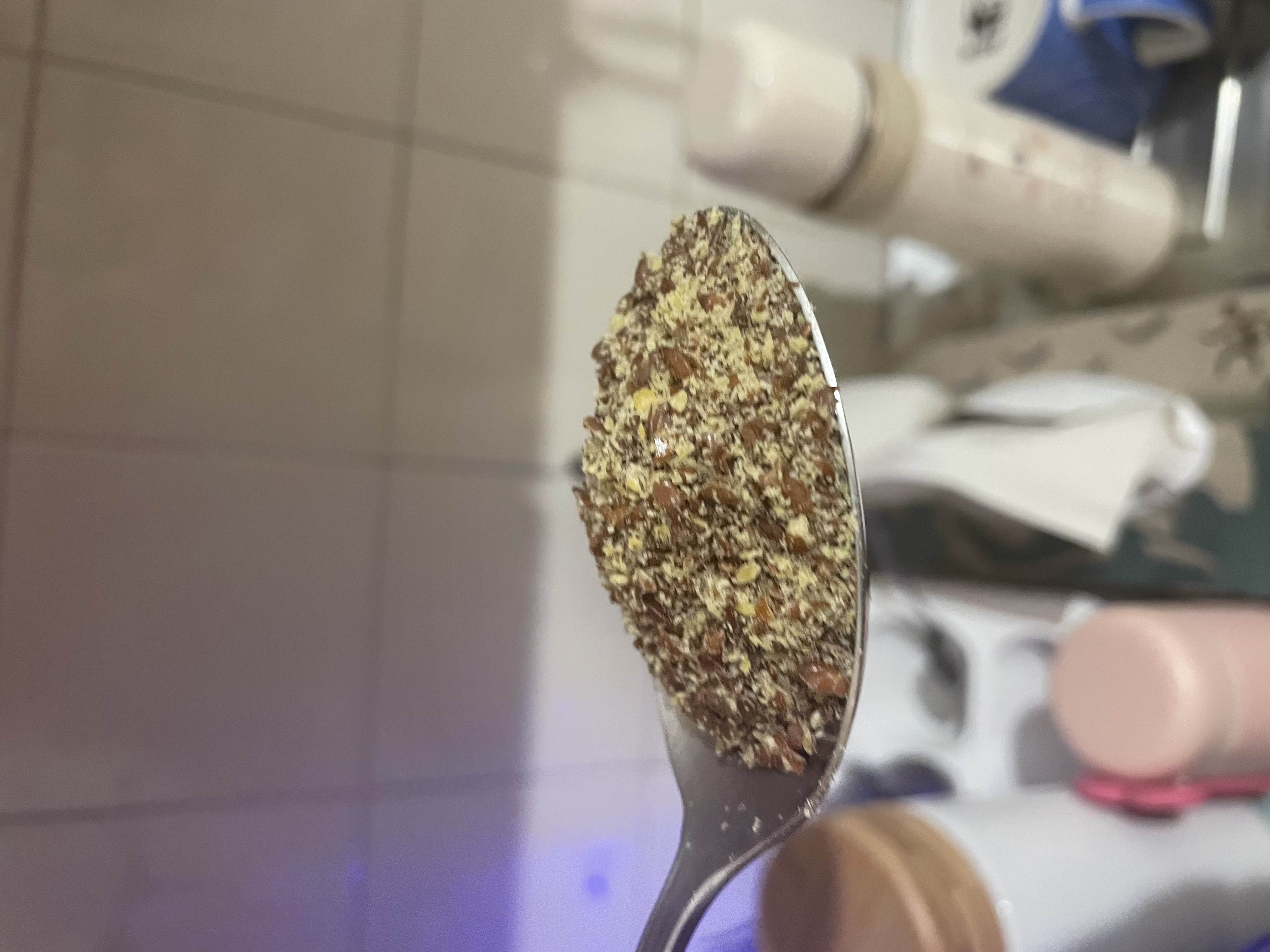 A spoonful of ground flaxseeds, a nutrient-dense ingredient rich in healthy fats, protein, and fiber.