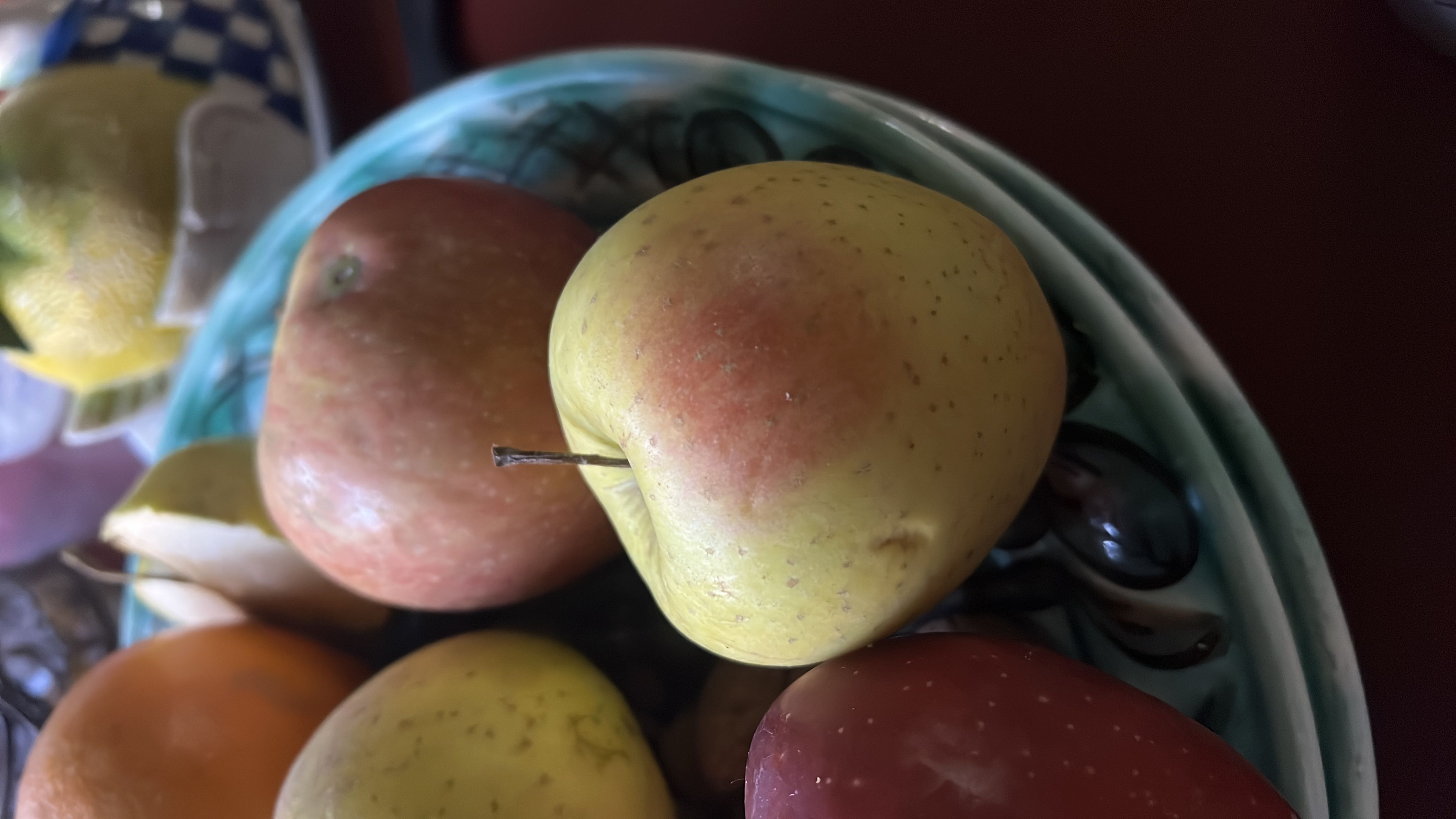 The image shows a bowl of fresh fruits, including apples, which are nutritious and low in calories.