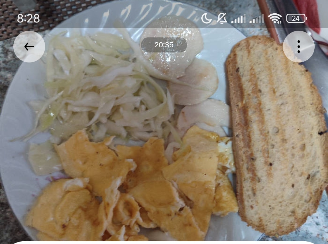 A balanced meal consisting of scrambled eggs, cabbage salad, boiled yam, and toasted bread, providing a mix of protein, carbs, and fats.