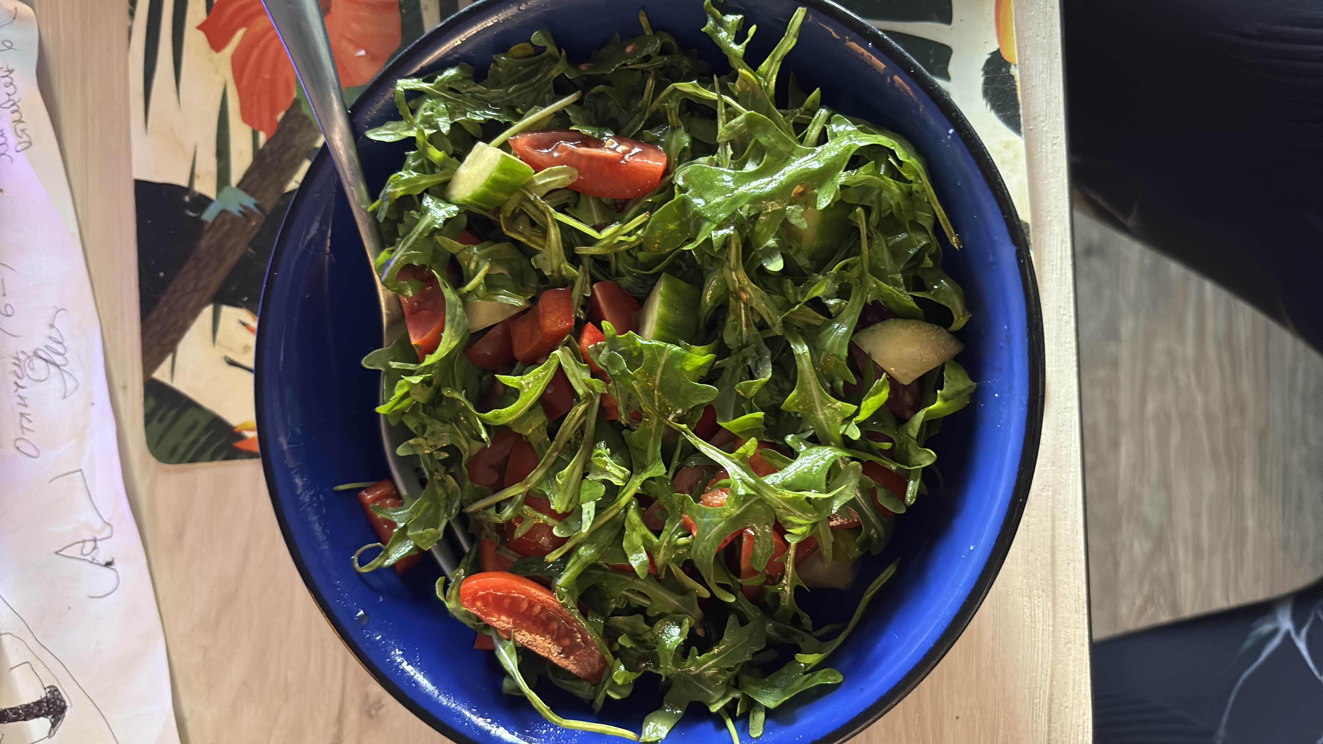 A fresh and healthy salad made with arugula, cherry tomatoes, cucumber, and a drizzle of olive oil.