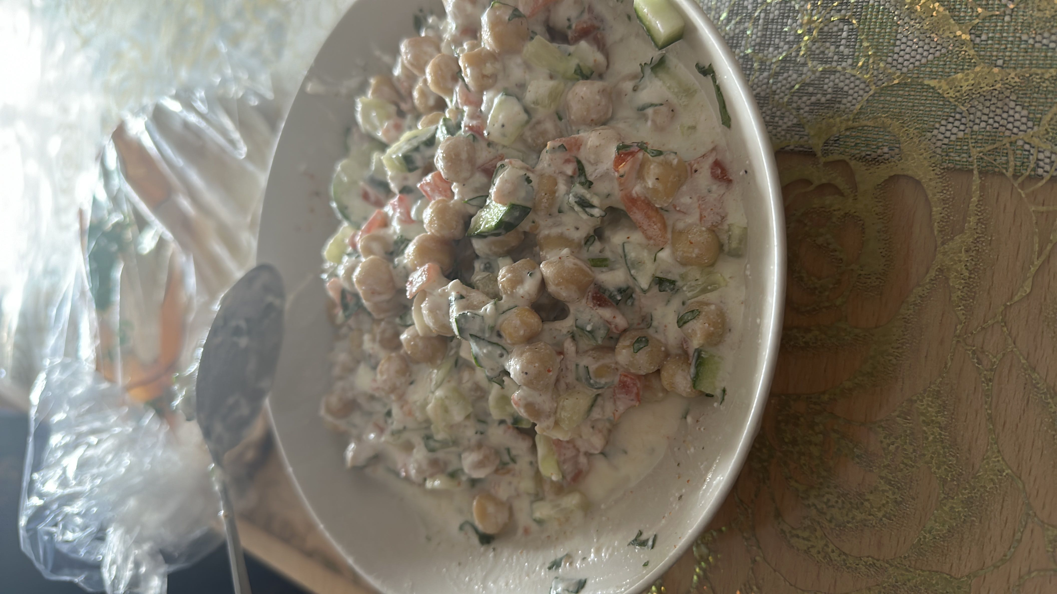 A healthy chickpea salad with yogurt, fresh vegetables, and herbs, providing a balanced mix of protein, carbs, and fats.