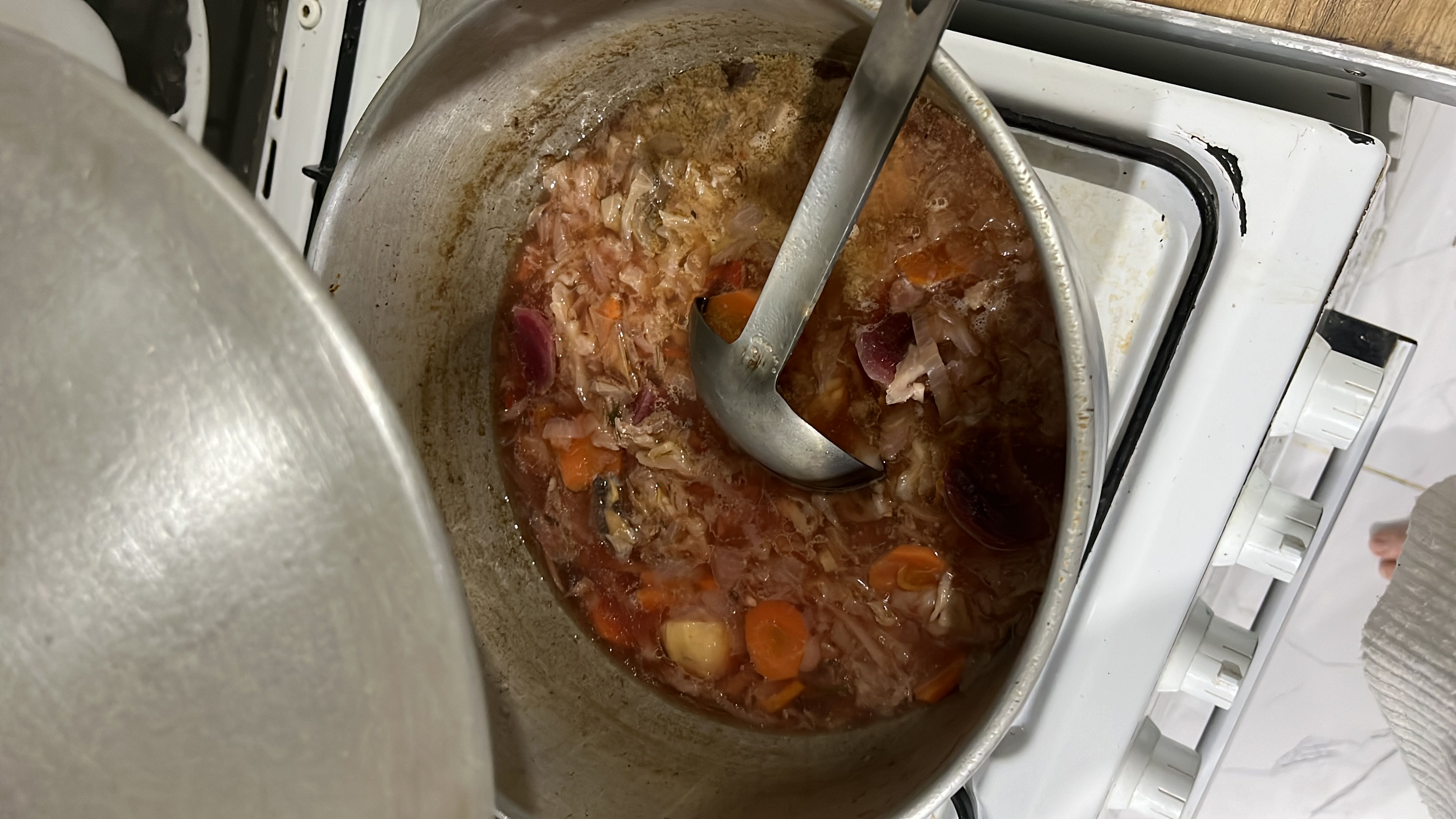 A nutritious soup containing vegetables like carrots, cabbage, onions, and tomatoes, along with chicken, providing a balanced mix of protein, carbs, and fats.