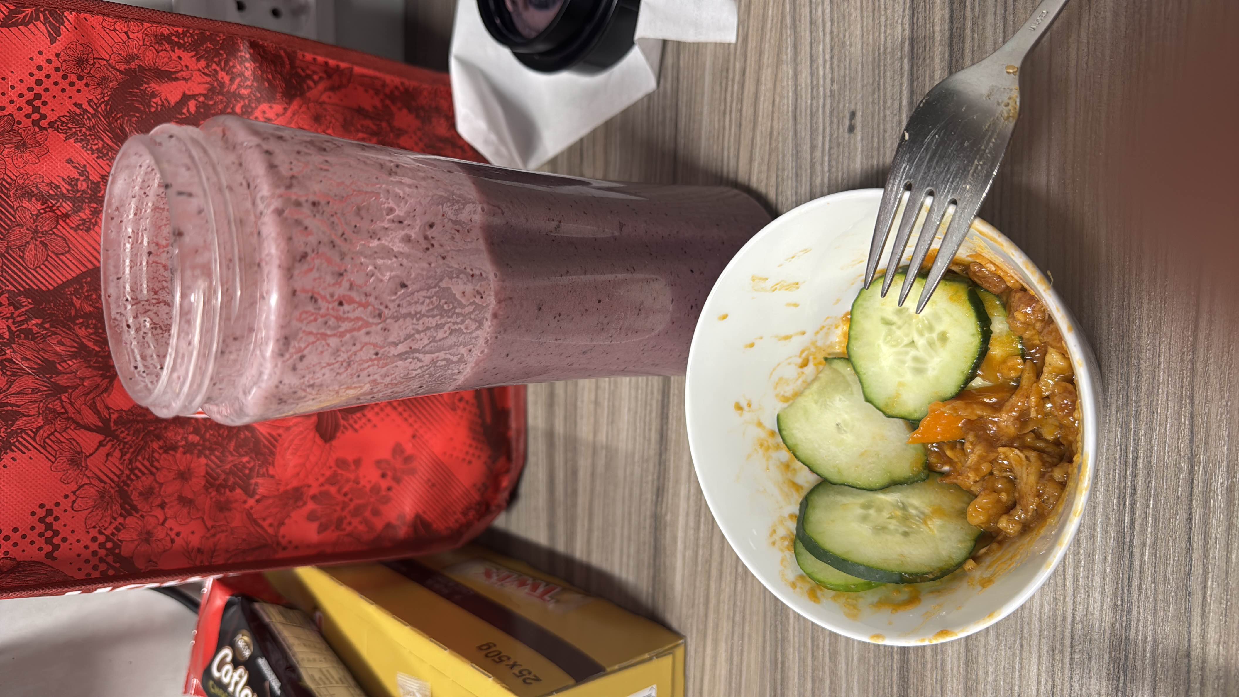 A meal with sweet and sour turkey in a small bowl, cucumber on the side, and a blueberry banana smoothie with chia seeds, yogurt, almond milk, and honey.