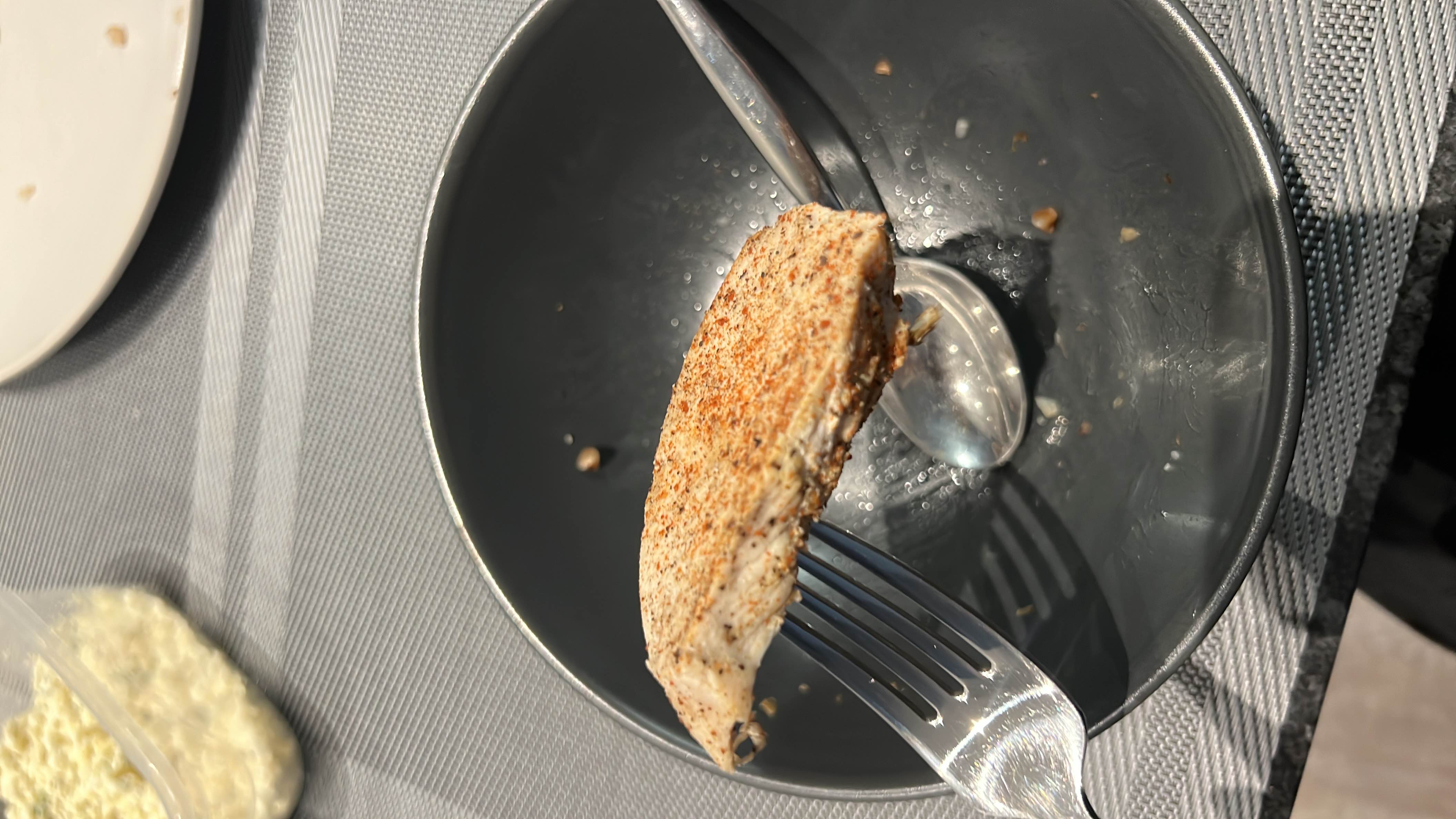 A serving of grilled chicken breast seasoned with spices, providing high protein and low fat content.