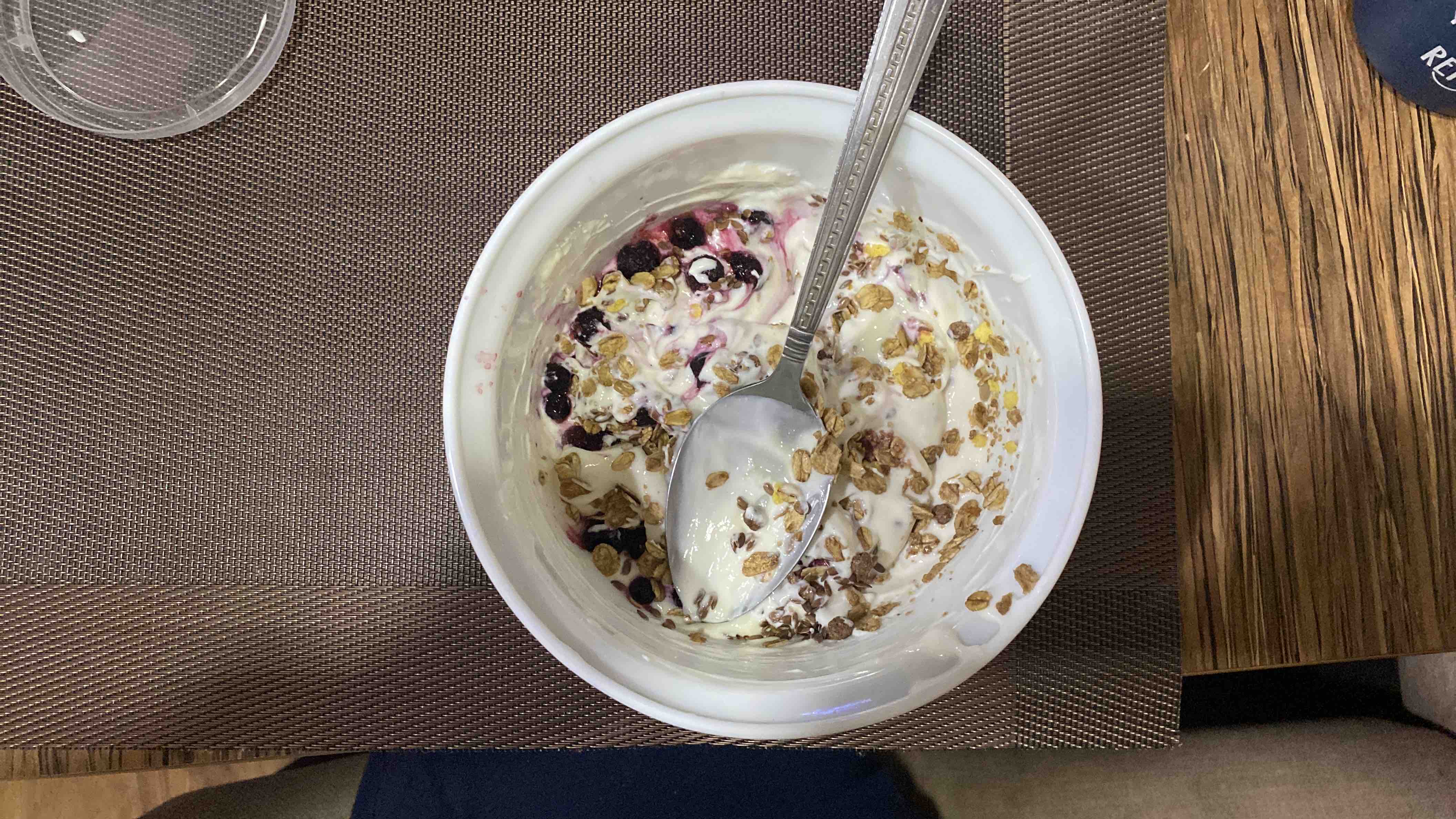 A bowl of Greek yogurt topped with berries, granola, flax seeds, and added protein, providing 303 calories, 35g protein, 25g carbs, and 7g fats.