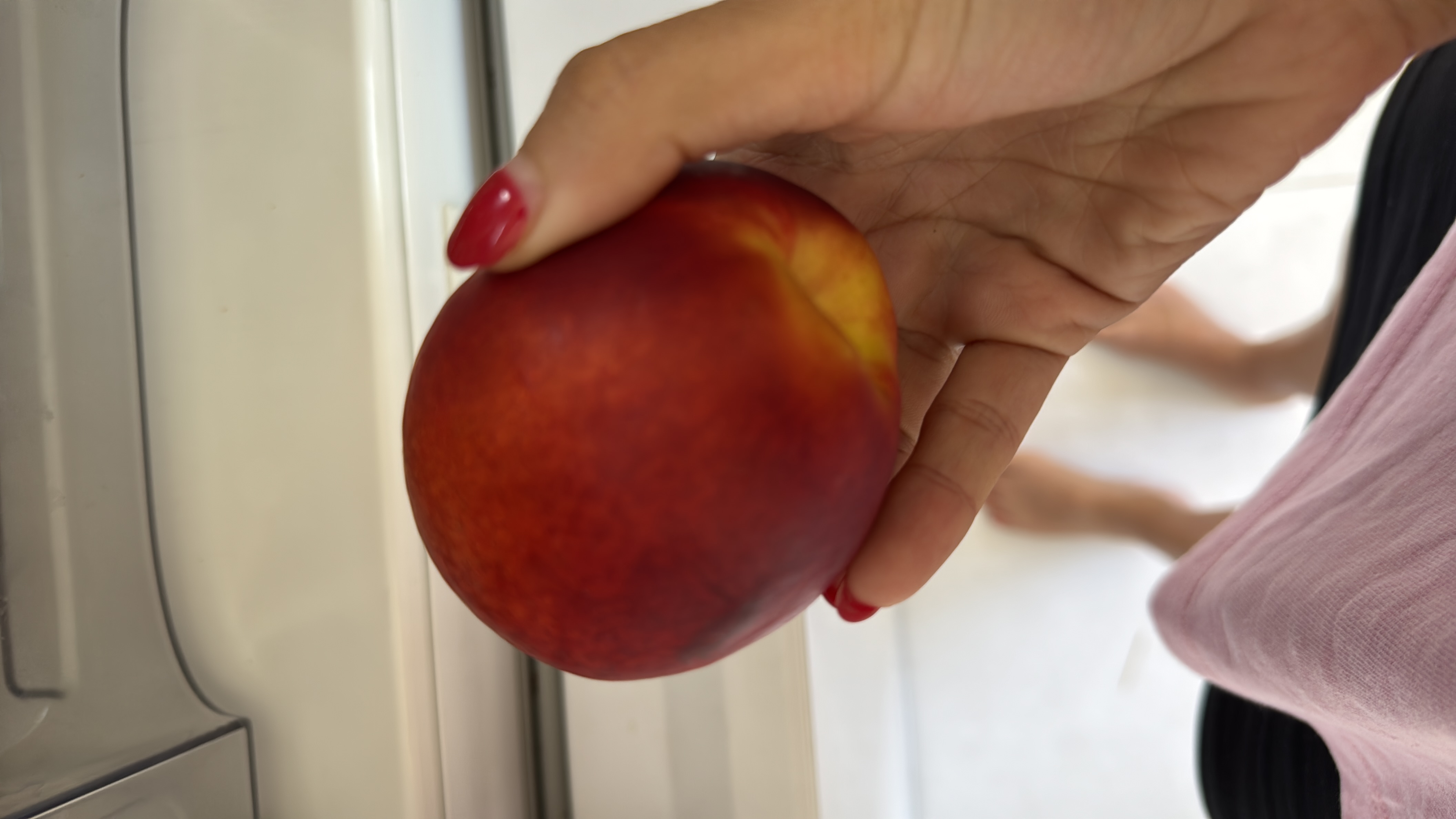 The image shows a nectarine, a low-calorie fruit rich in carbohydrates and minimal fats, making it a healthy snack option.