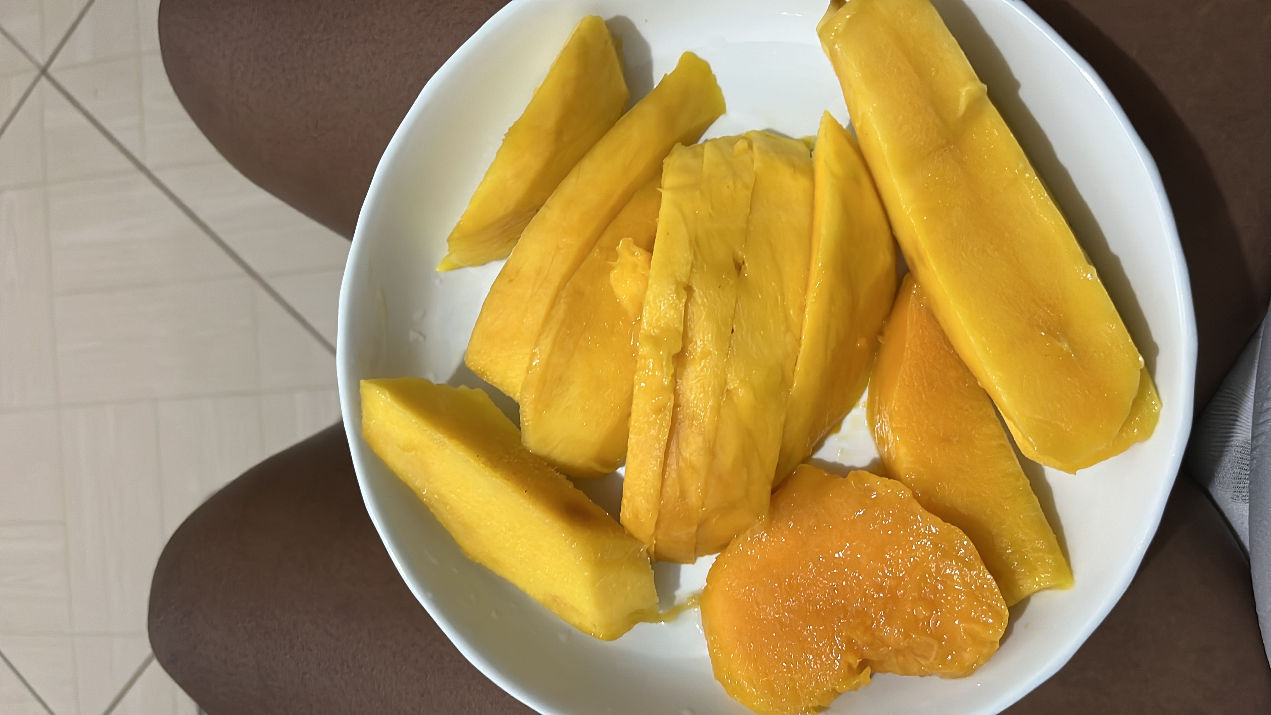 A bowl of fresh mango slices, rich in natural sugars, vitamins, and fiber, providing a healthy and refreshing snack.