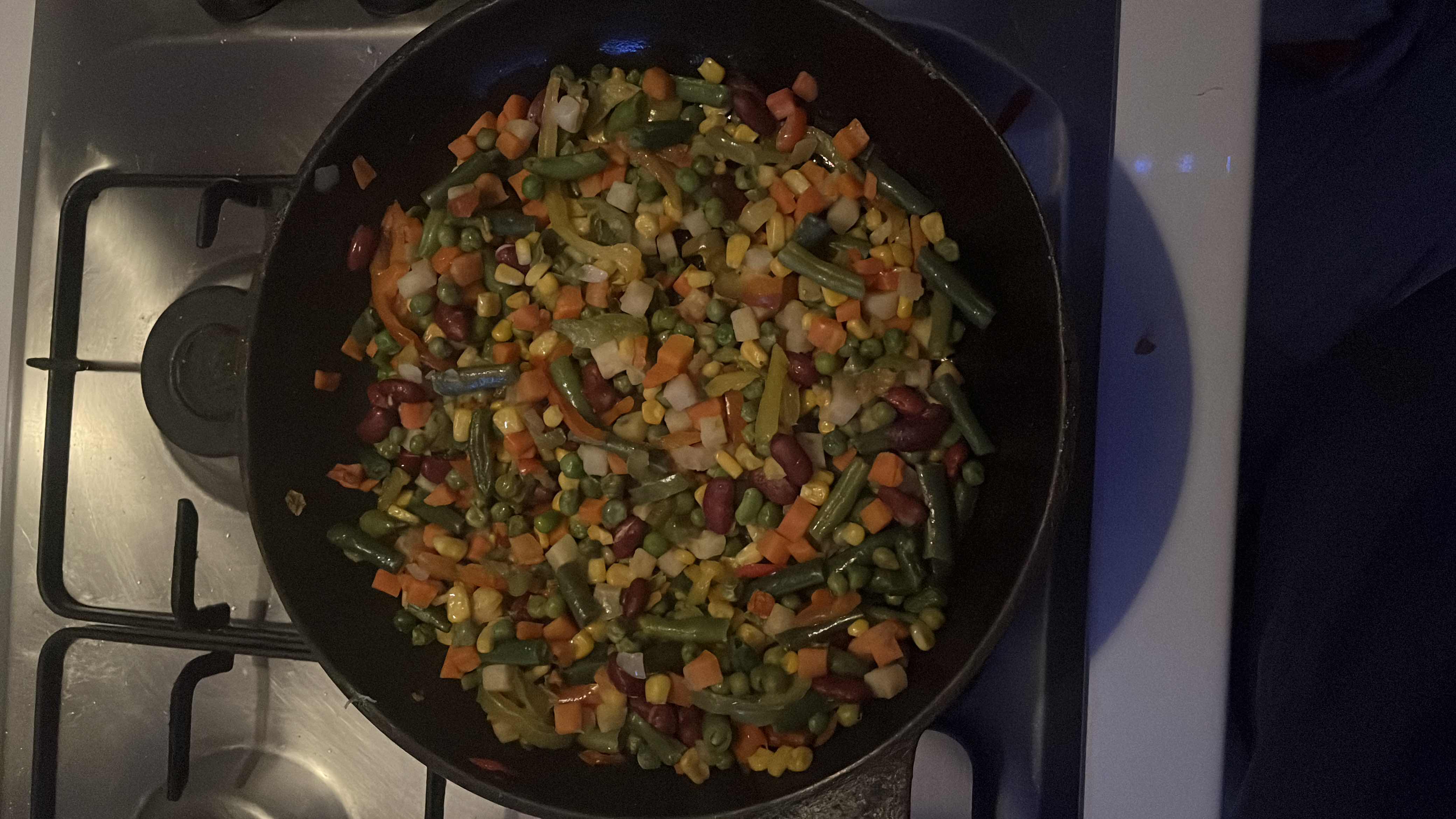 A colorful vegetable medley stir-fry containing green beans, carrots, corn, kidney beans, and peas, offering a nutritious and balanced meal.